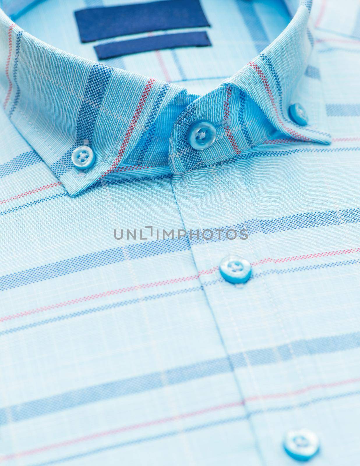striped shirt with a focus on the collar and button, close-up
