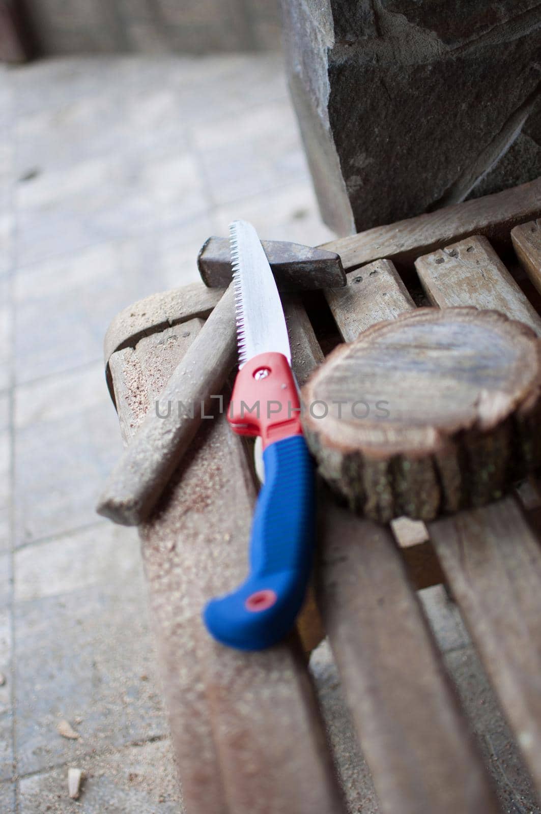 an old hammer, a hand saw and a round bar of pine with sawdust on a bench. Wooden stand for food for the master class. DIY concept.