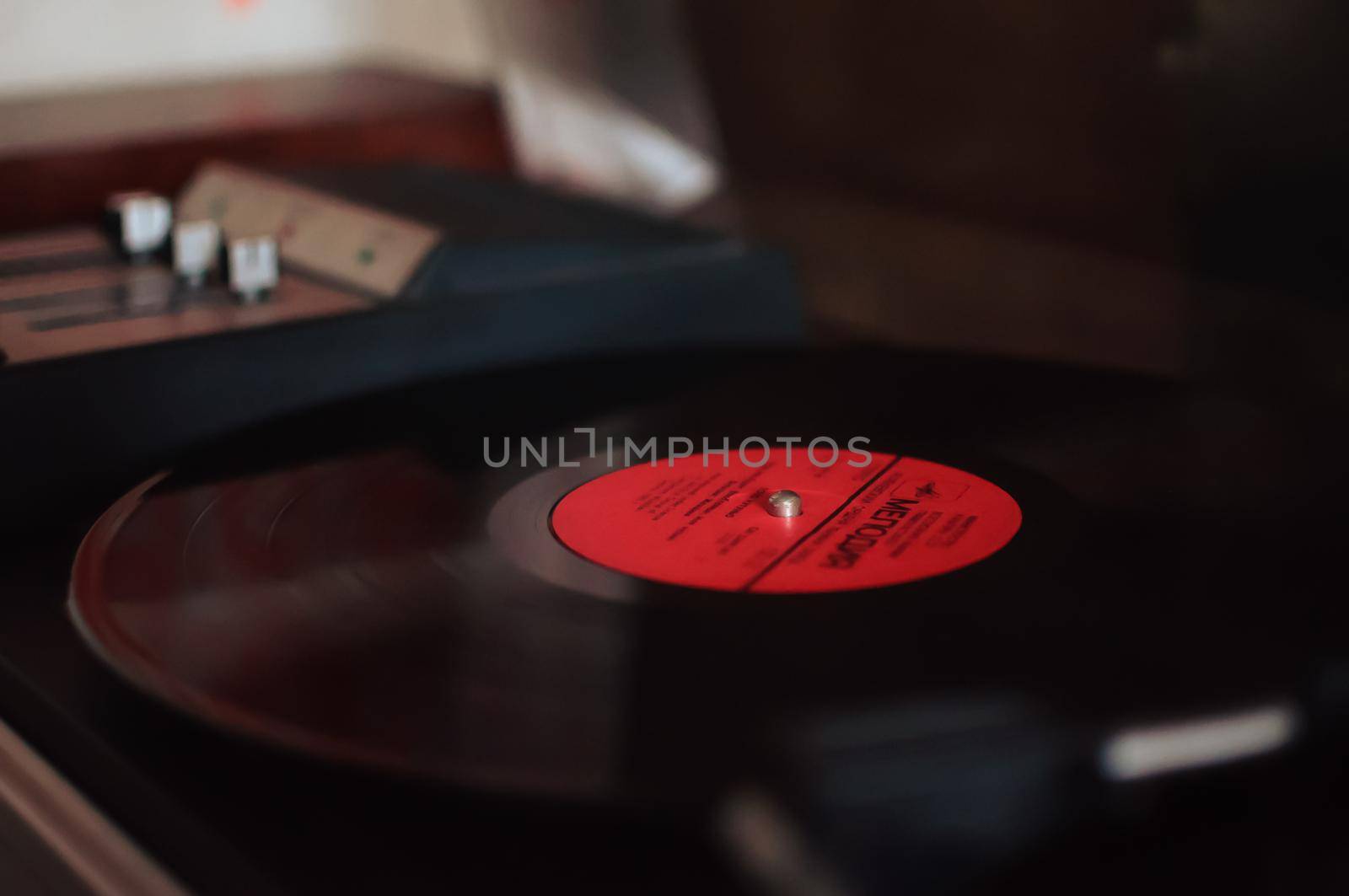 Vinyl record player on a sunset background over the city lights. Sound technology for DJs to mix and play music. Black vinyl record. 1980 vintage vinyl wood record player. Vinyl record needle