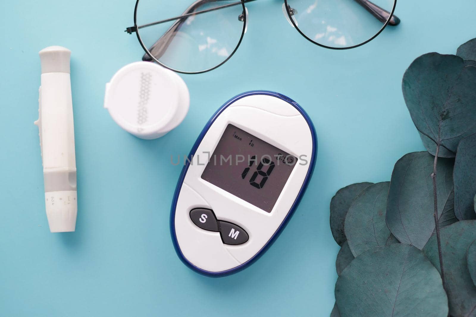 Close up of diabetic measurement tools and pills on pink background .