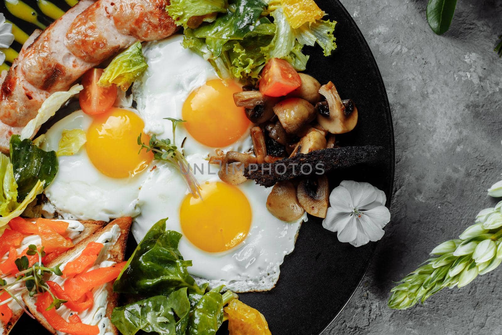 Full English breakfast with toast bread, chicken egg, mustard sauce, champignons, salad mix, cheese cream, sweet pepper.