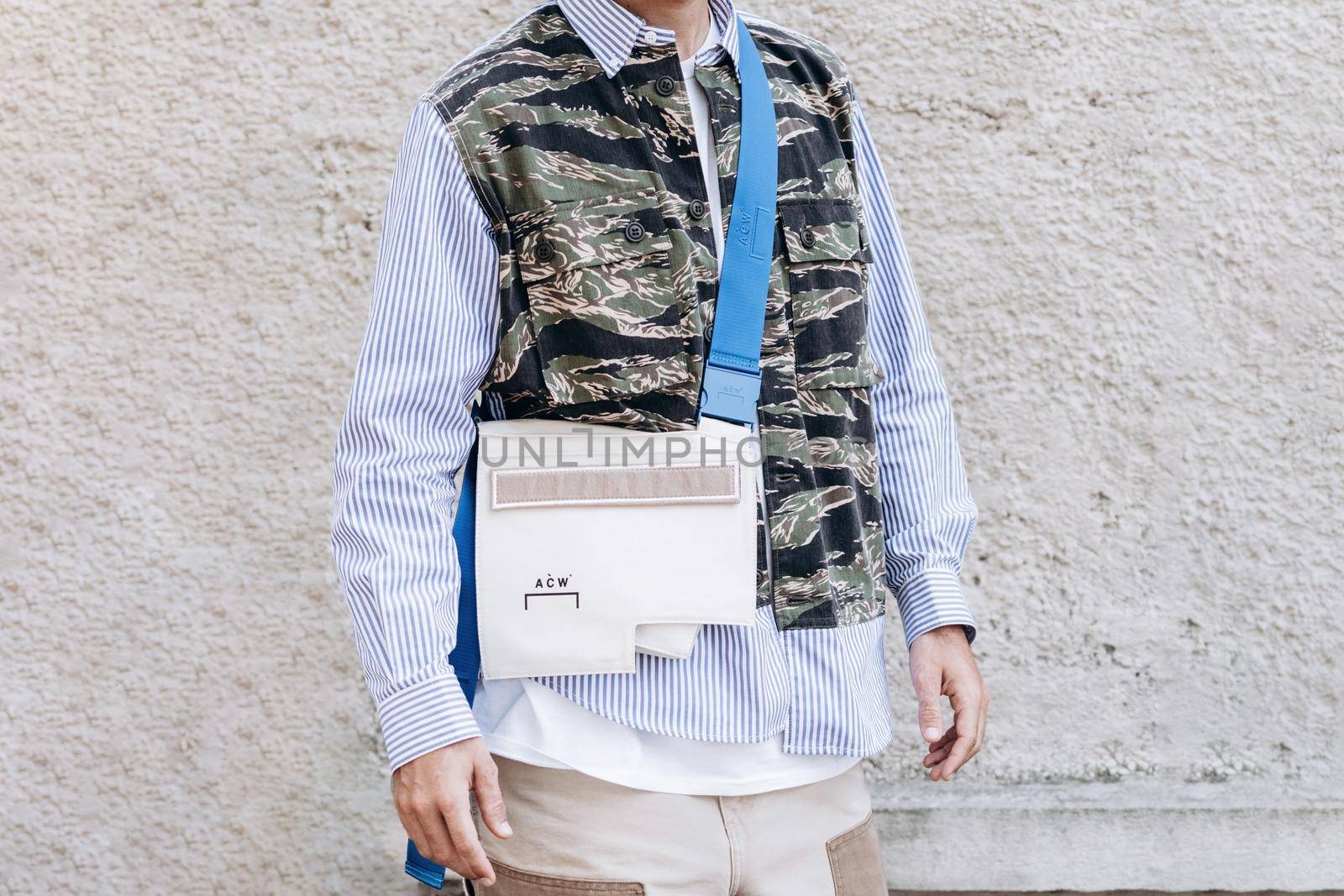 Milan, Italy - September 24, 2021: street style fashion outfit details, man wearing striped shirt and military belt