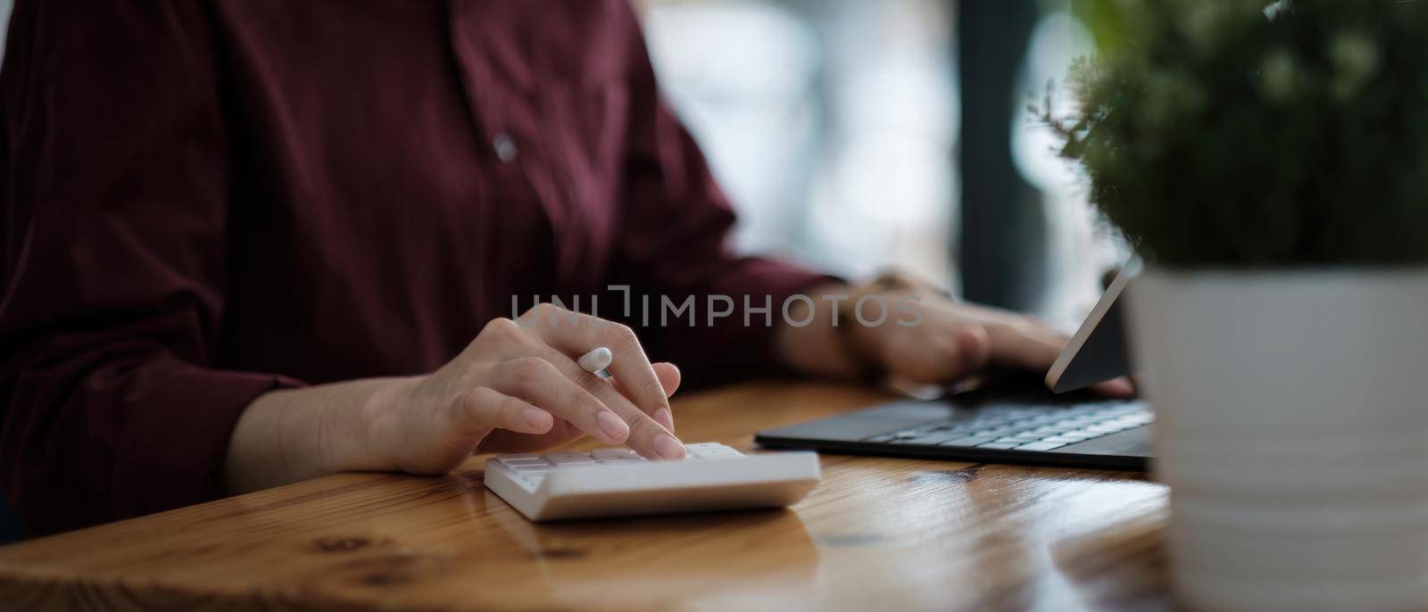 Close up hand of accountant working with computer and calculator for business and financial expense by nateemee