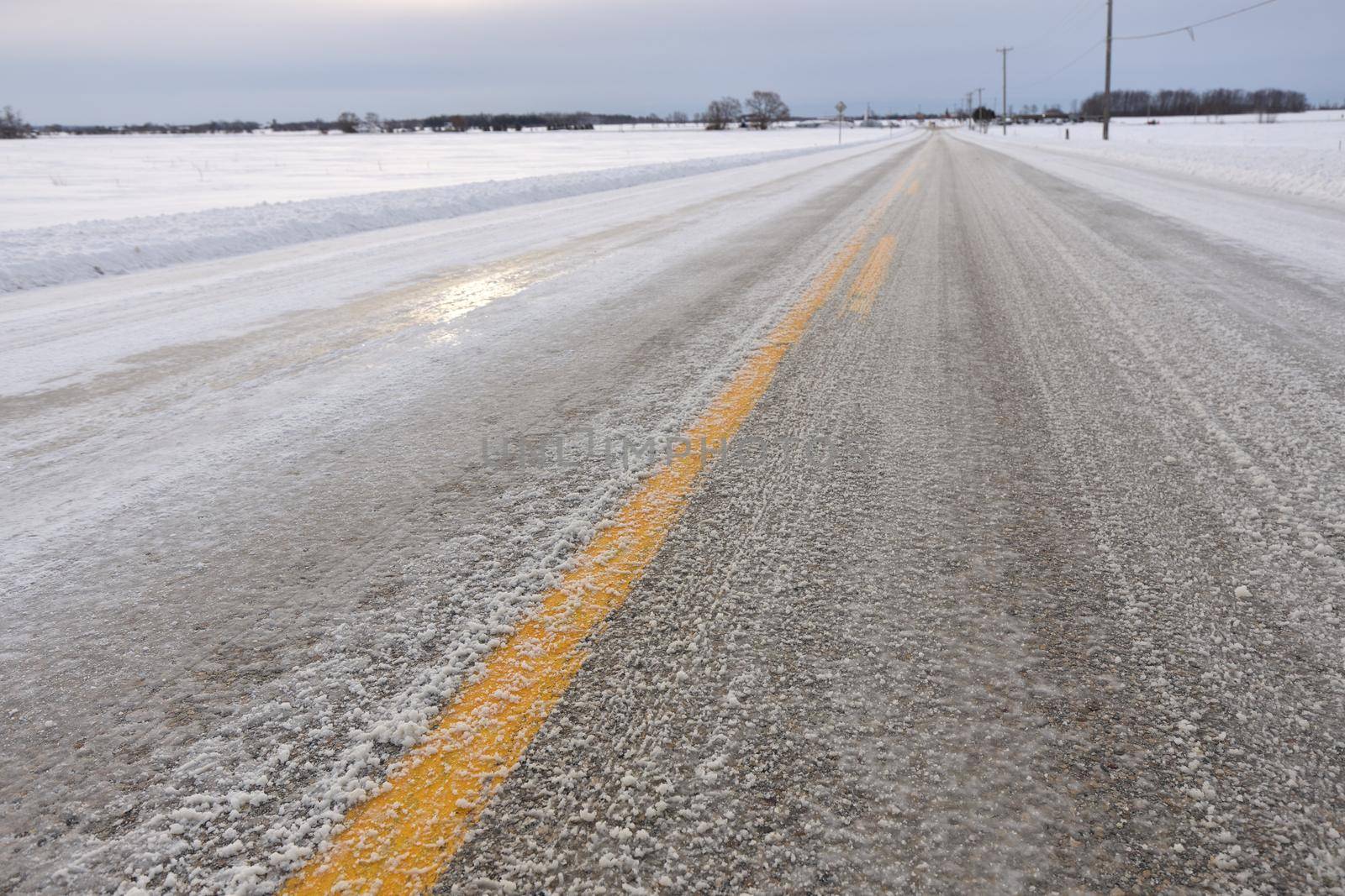 Close up of Slippery Icy Slushy Pavement Road in Winter in Rural Setting. High quality photo