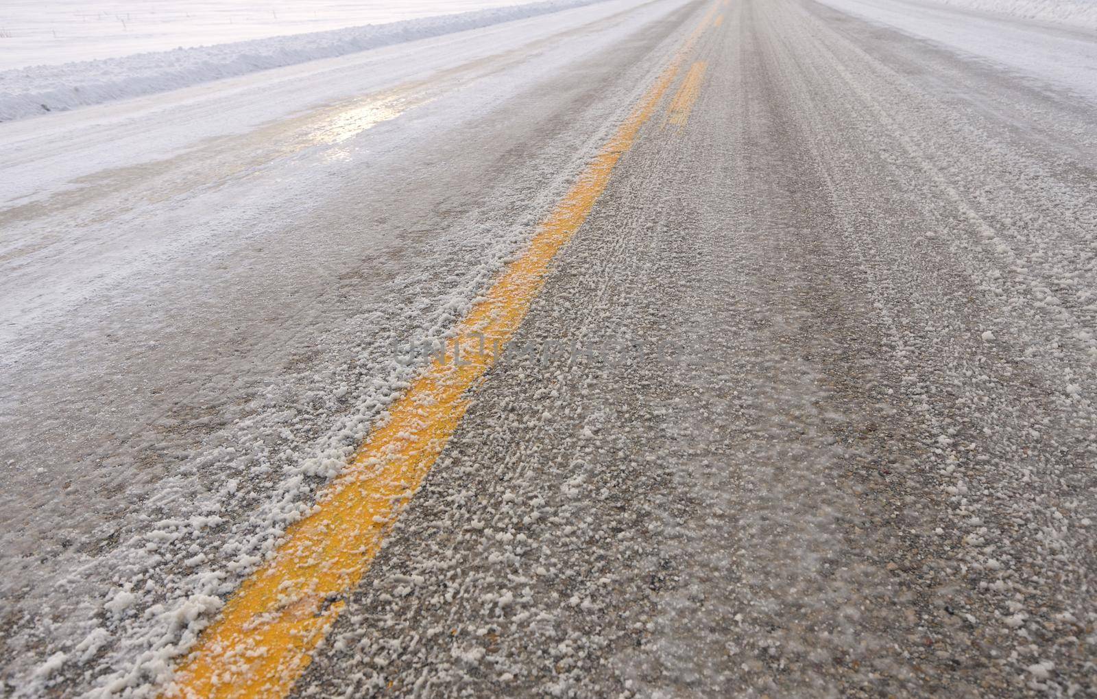 Close up of Slippery Icy Slushy Pavement Road in Winter in Rural Setting. High quality photo