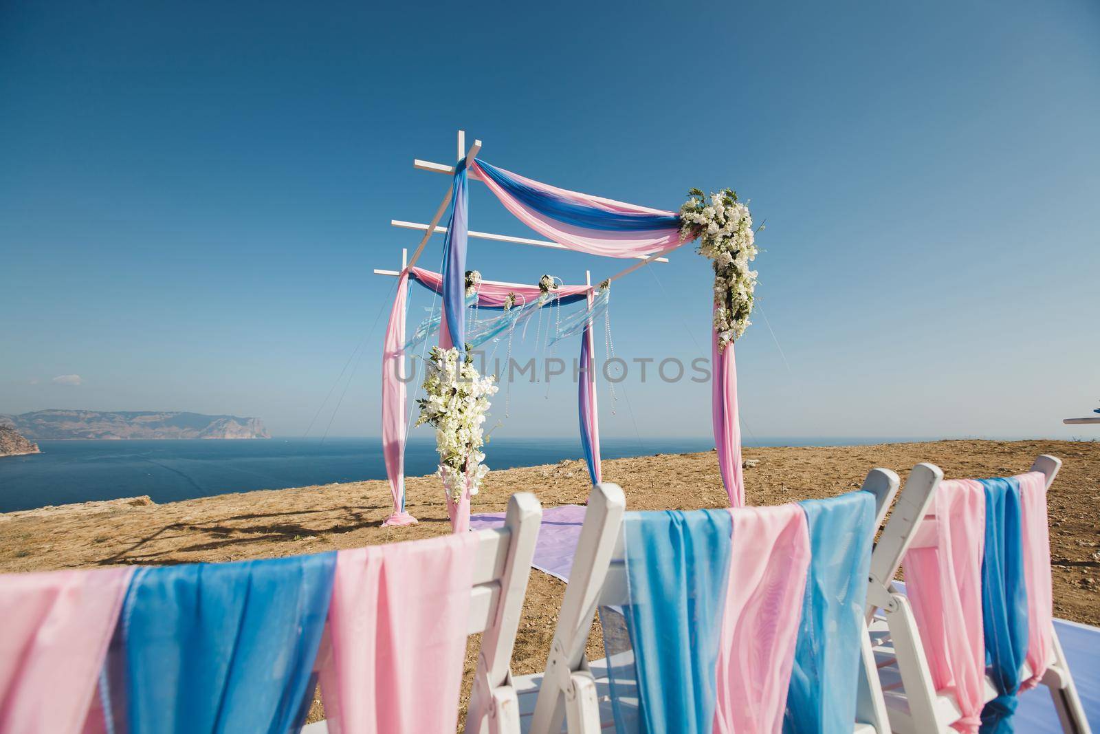 Wedding arch pink color on the background of the sea by StudioPeace