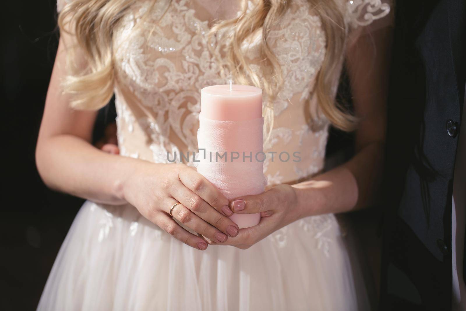 Wedding ceremony, paraphernalia, the bride and groom hold a large candle in their hand