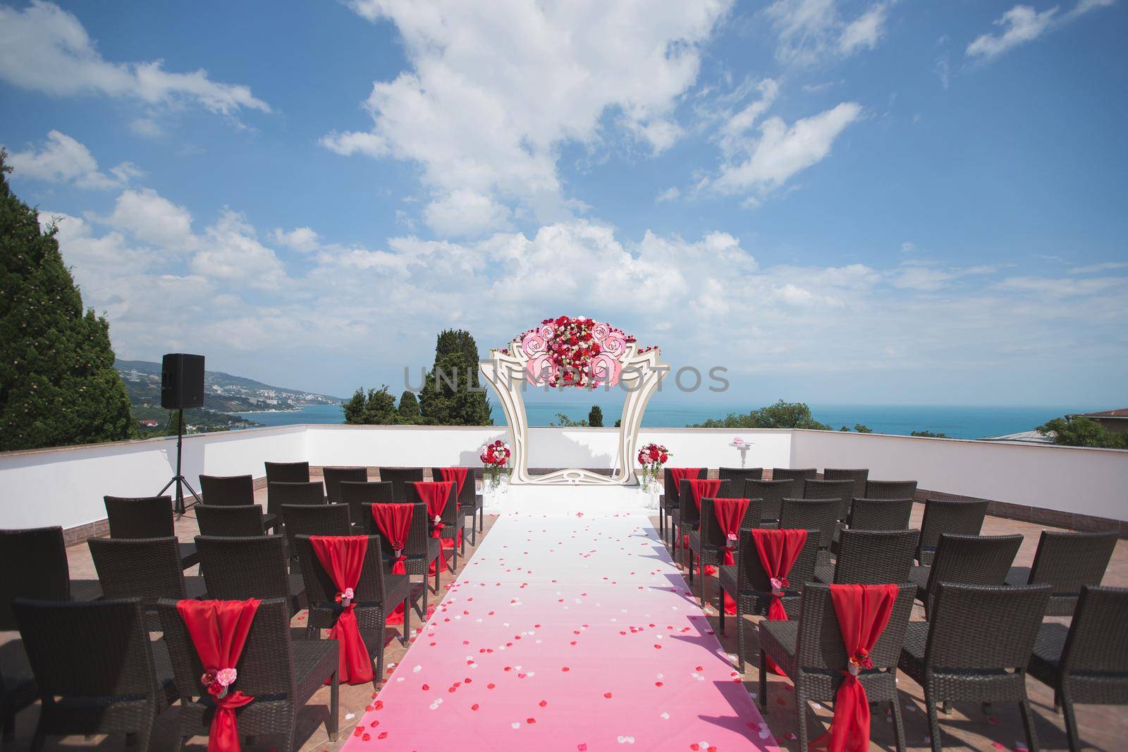 Arch red for the wedding ceremony in the sea. Mountain.