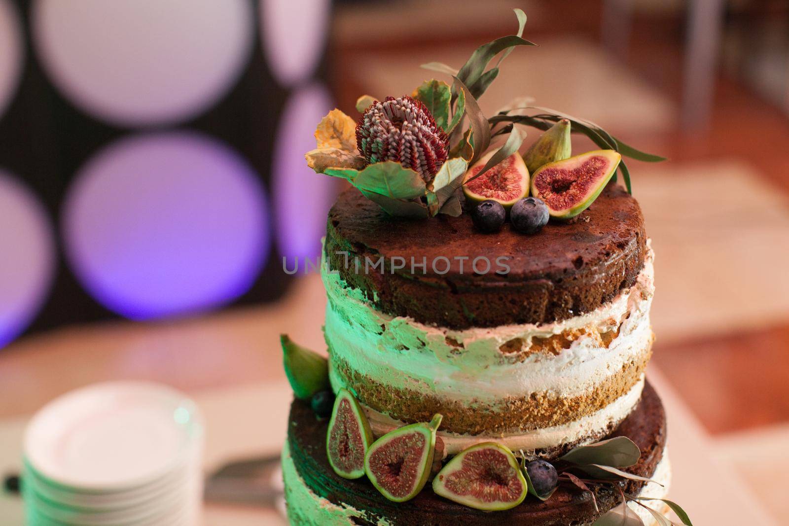 Delicious chocolate cake with figs and berries. Wedding Naked cake with fruits in rustic style by StudioPeace