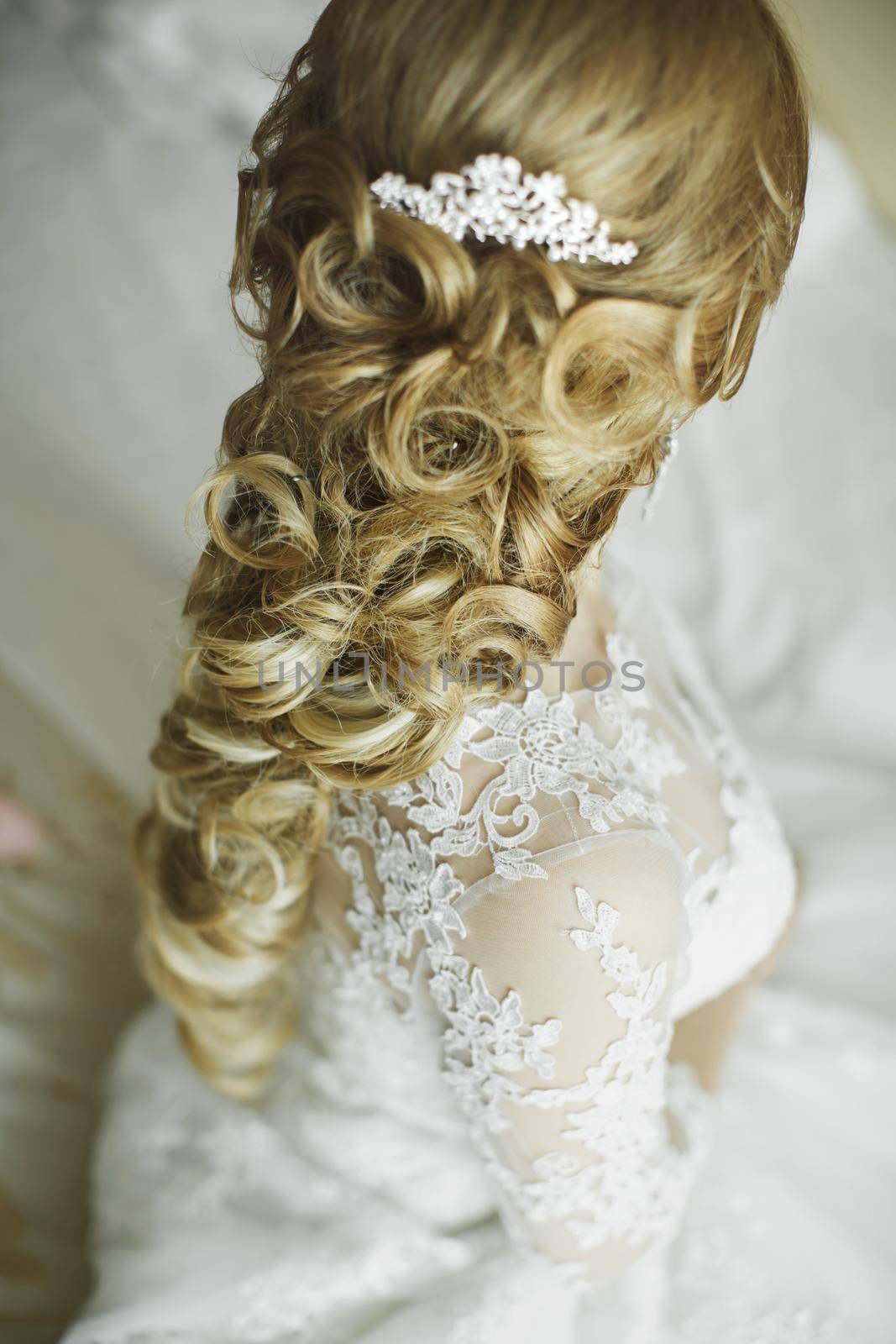 Hair stylist makes the bride a wedding hairstyle with fresh flowers. by StudioPeace