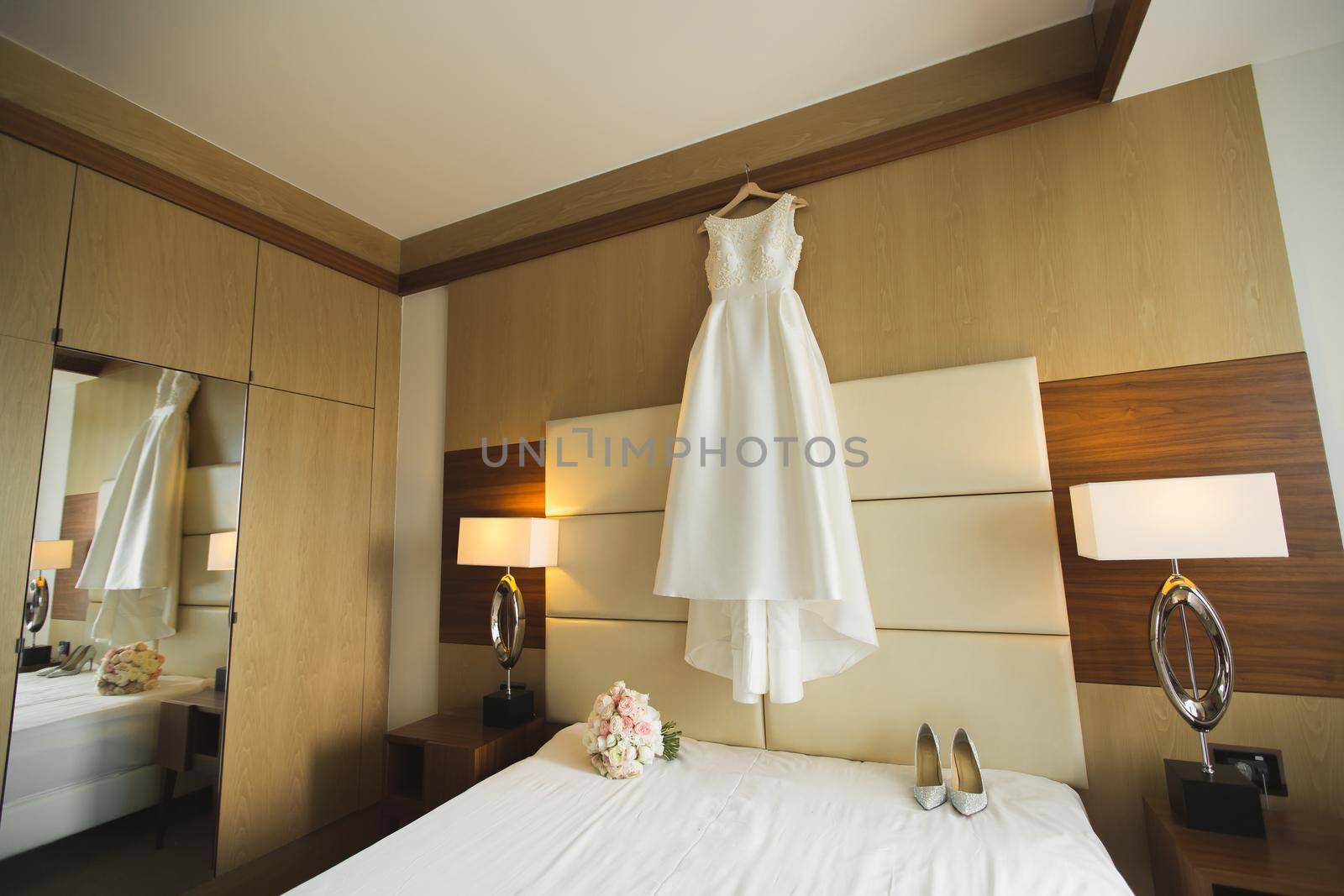 Beautiful wedding dress on hanger in room