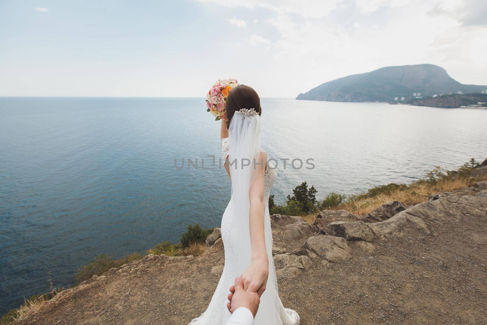 Beautiful young woman bride holds the hand of a man in outdoors. Follow me. by StudioPeace