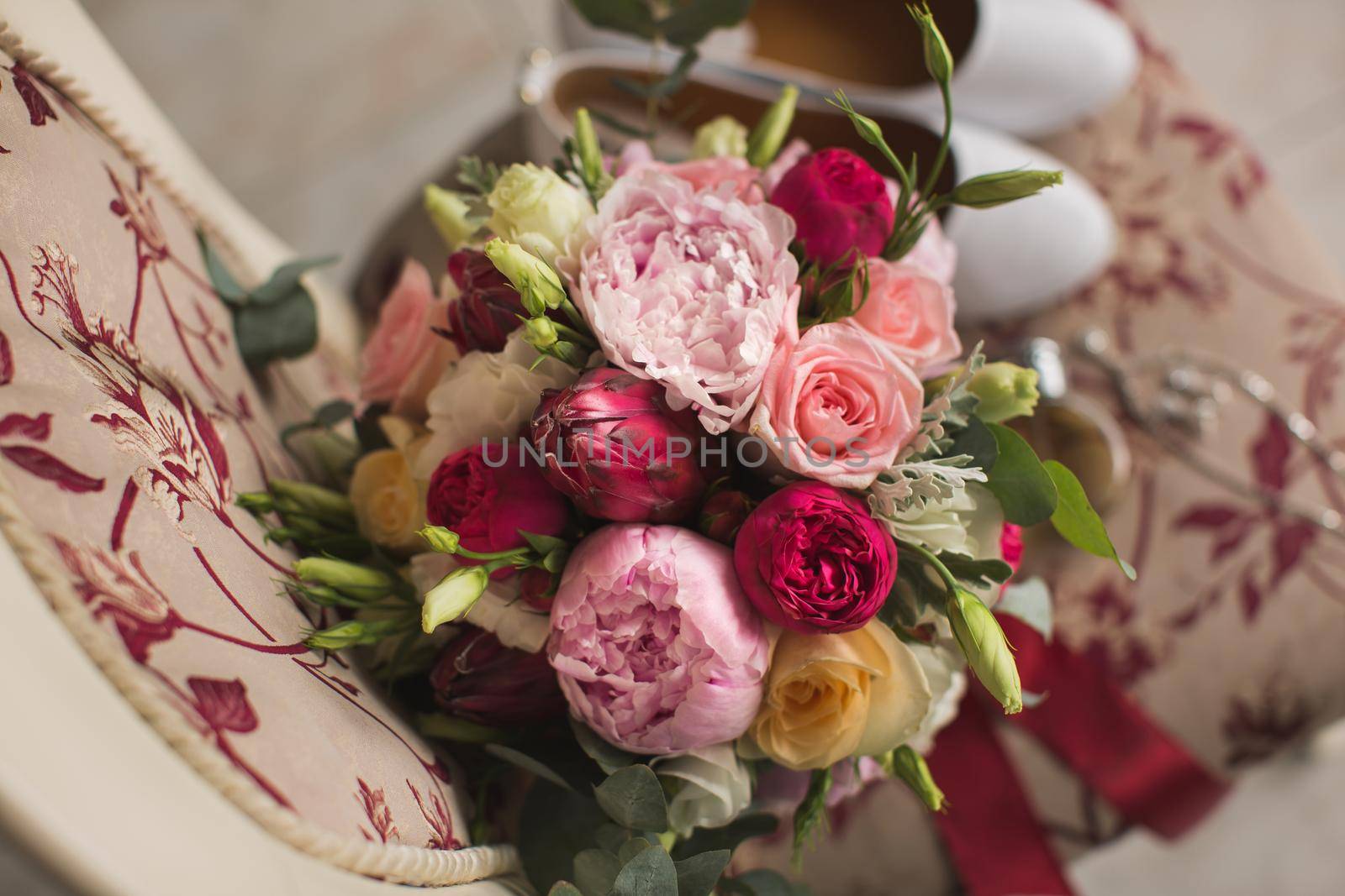 Wedding details. Accessories for the bride: a bouquet and shoes on a chair by StudioPeace