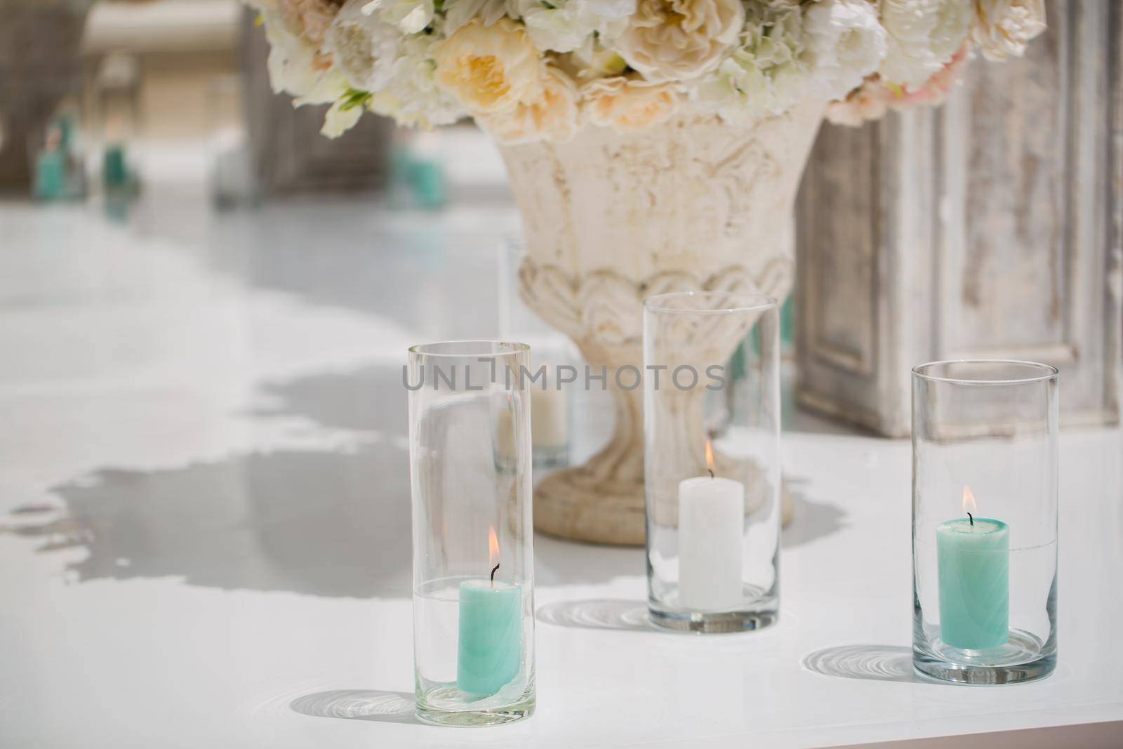 Beautiful bouquet of roses in a vase on a background of a wedding arch. Beautiful set up for the wedding ceremony by StudioPeace