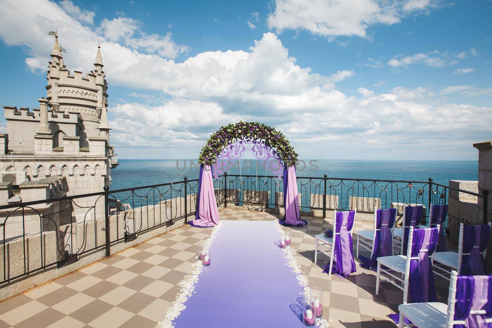 Wedding arch of purple color on the background of the sea by StudioPeace