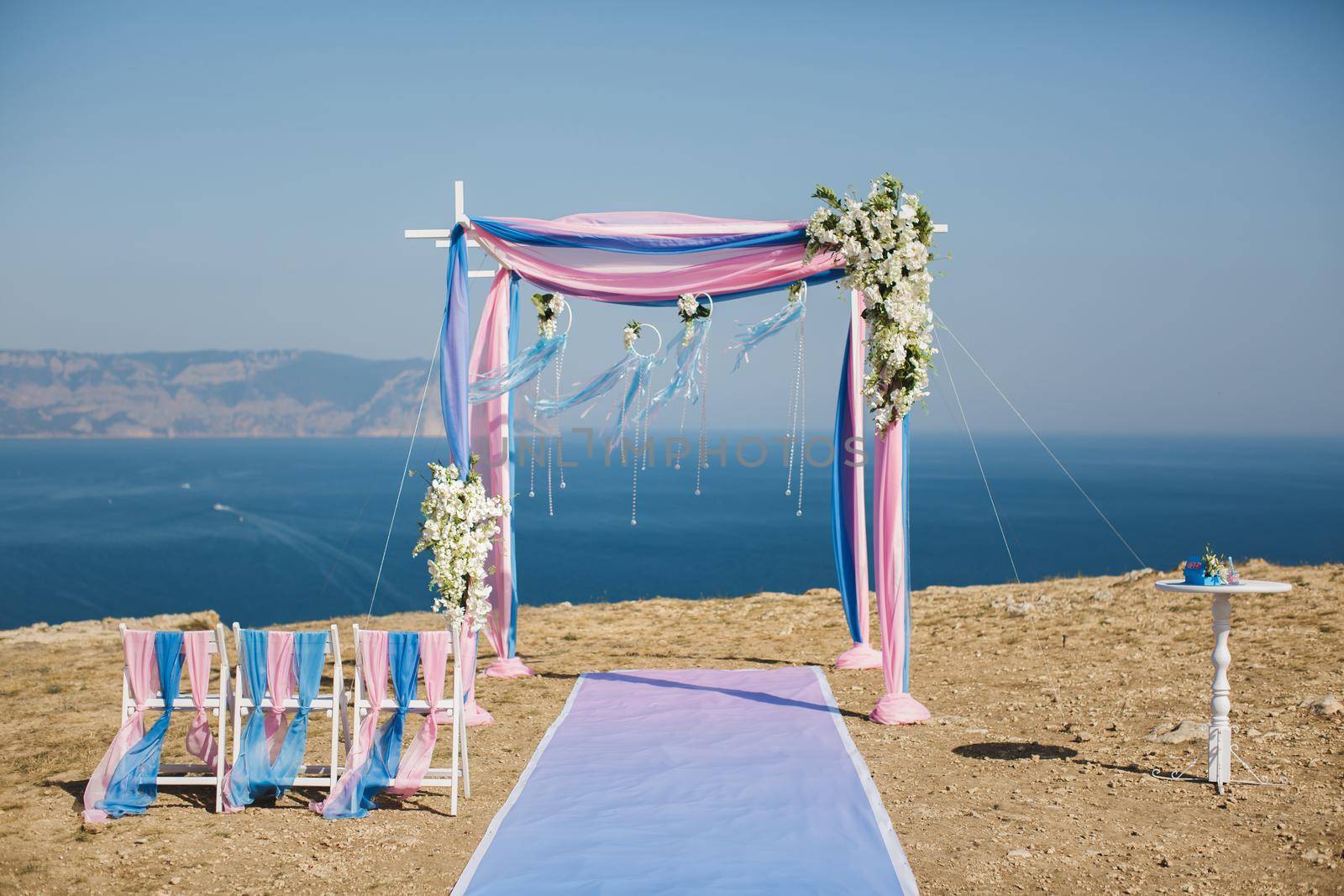 Wedding arch pink color on the background of the sea by StudioPeace