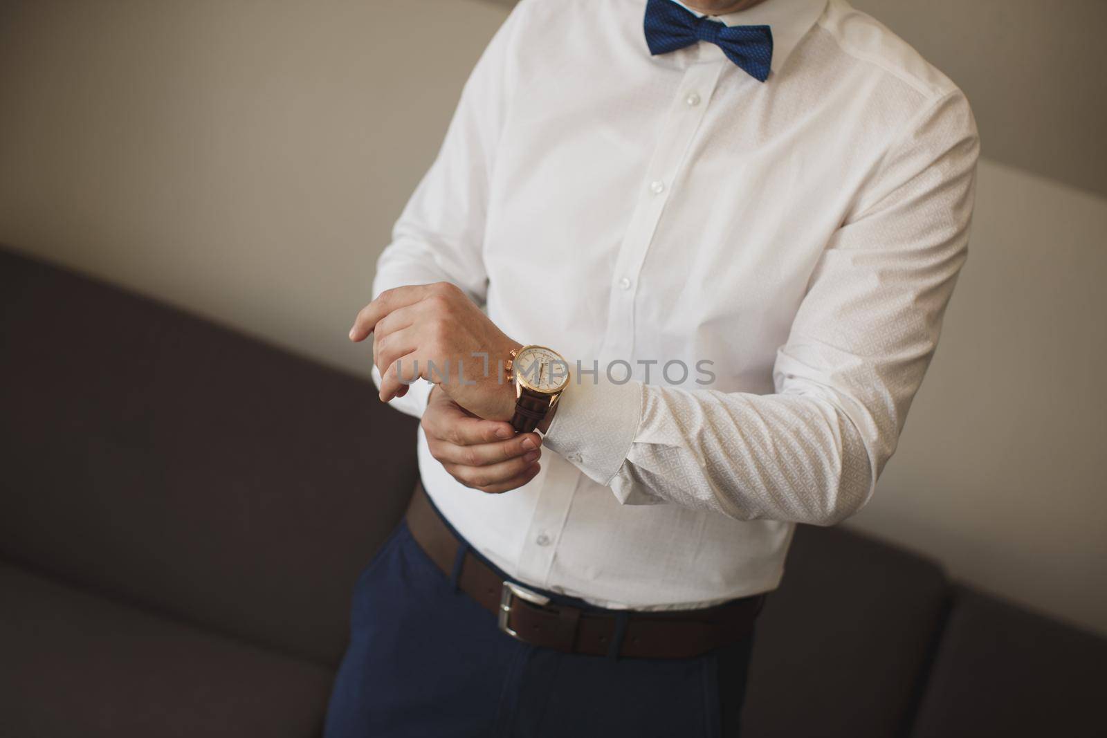 The groom's pack, who puts a watch on his hand.