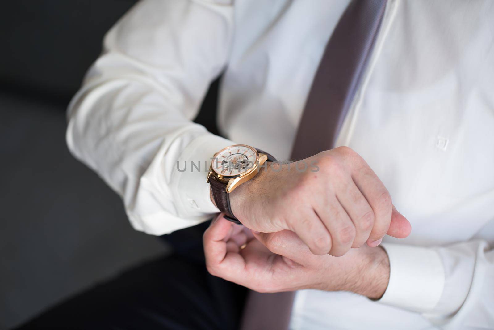 A man puts a watch on his hand. by StudioPeace