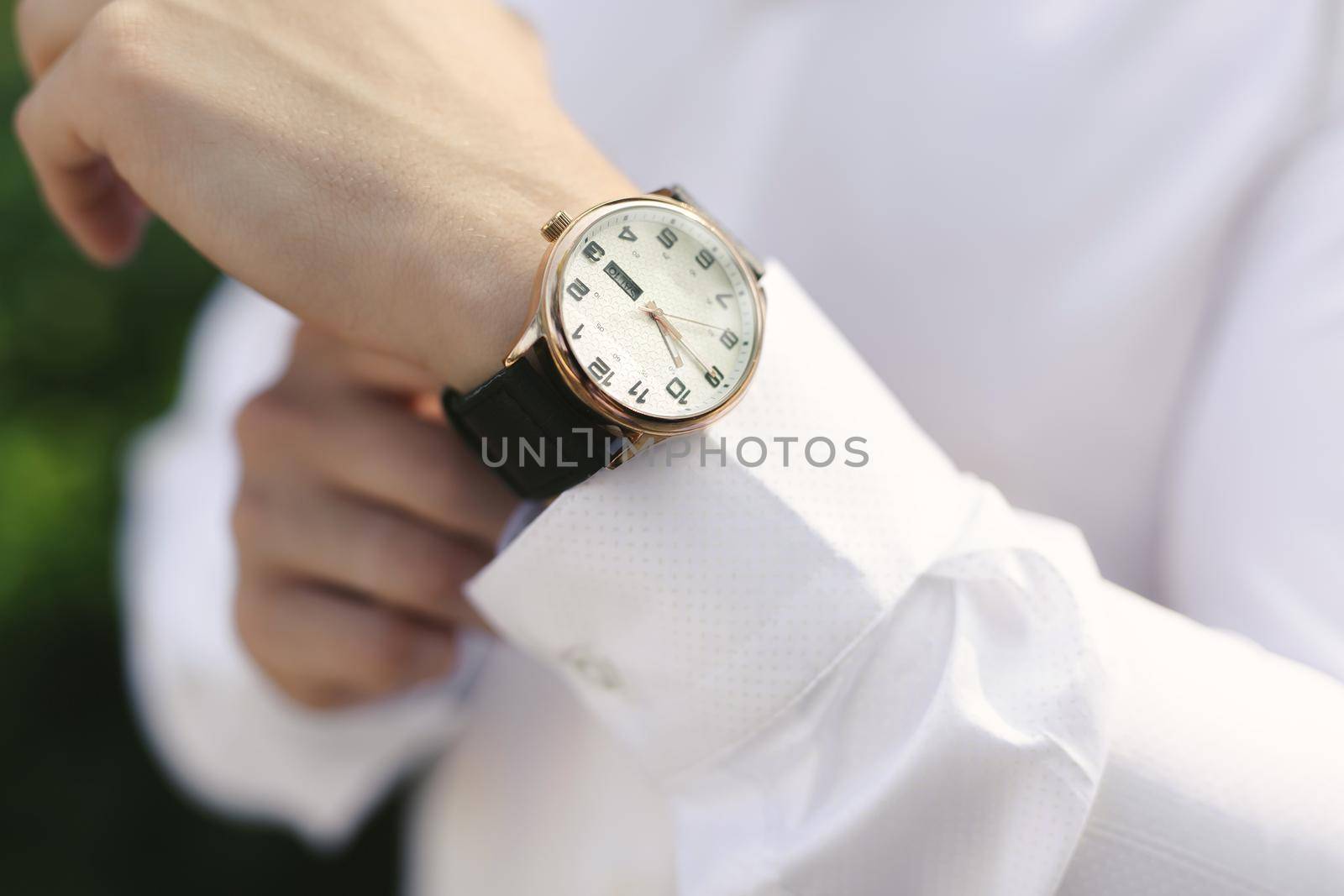 Close-up hands of the groom with a clock. by StudioPeace