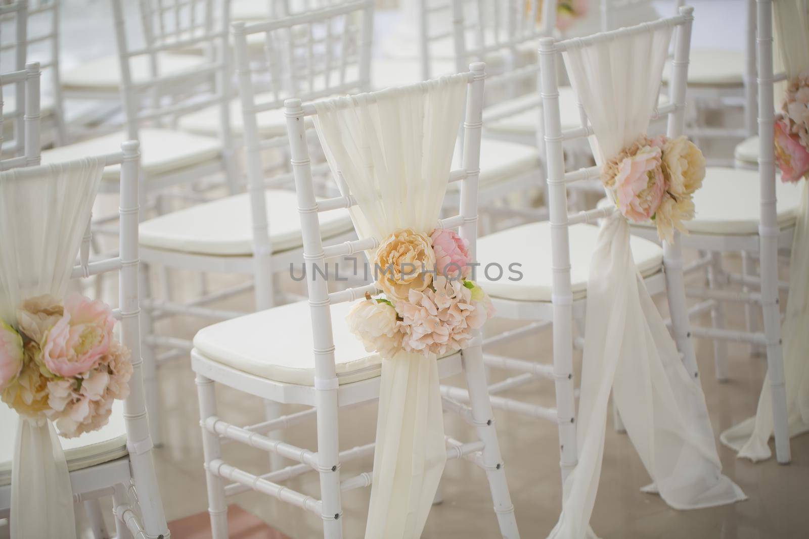 wedding decorations flowers on chairs. Wedding exit registration, white chairs decorated for wedding. wedding setup detail by StudioPeace