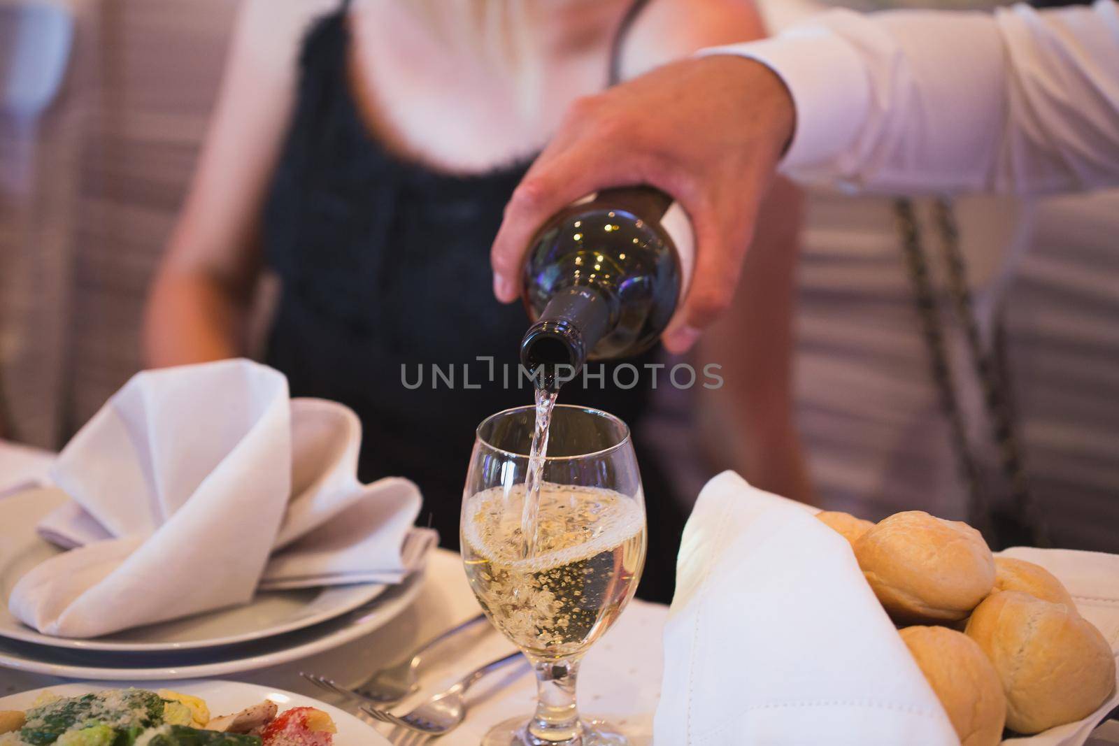 Man pours champagne from bottle to glass