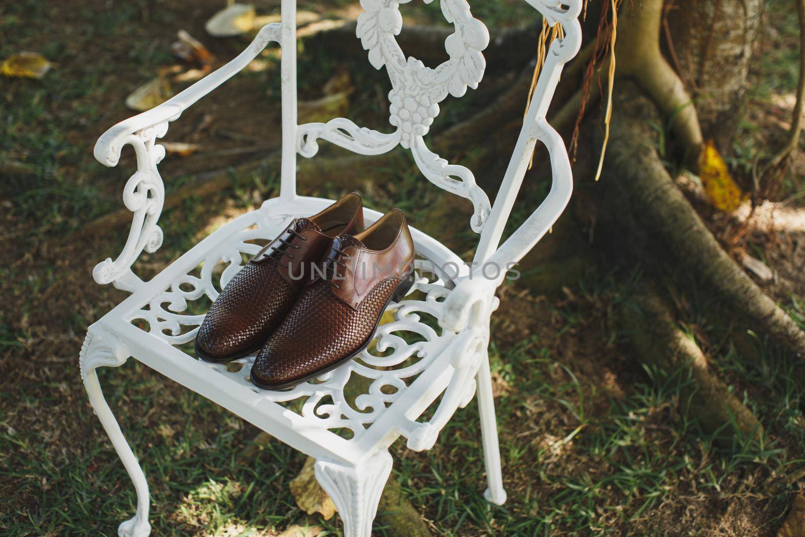 Men's shoes on a white chair on the wedding day by StudioPeace