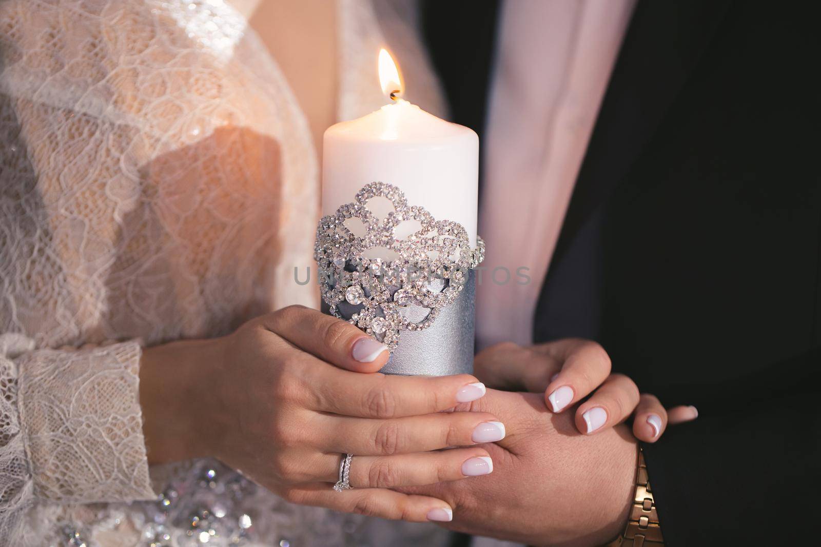 Wedding ceremony, paraphernalia, the bride and groom hold a large candle in their hand