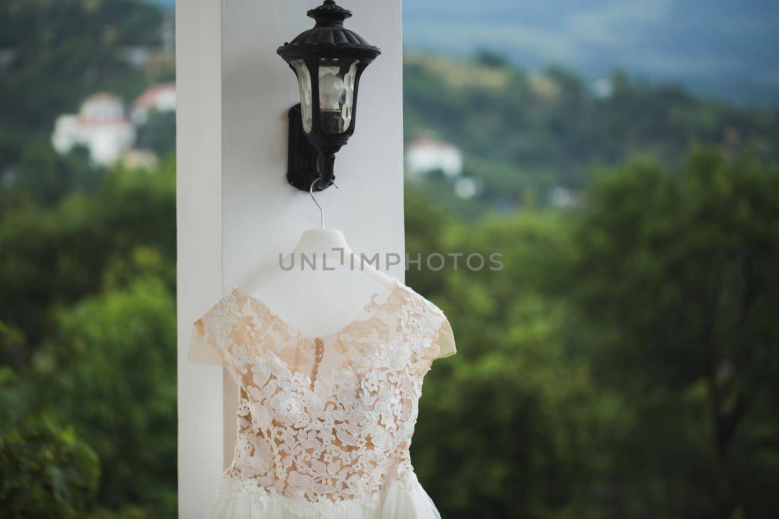 wedding dress hanging on a balcony on a background of snow-capped mountains. by StudioPeace