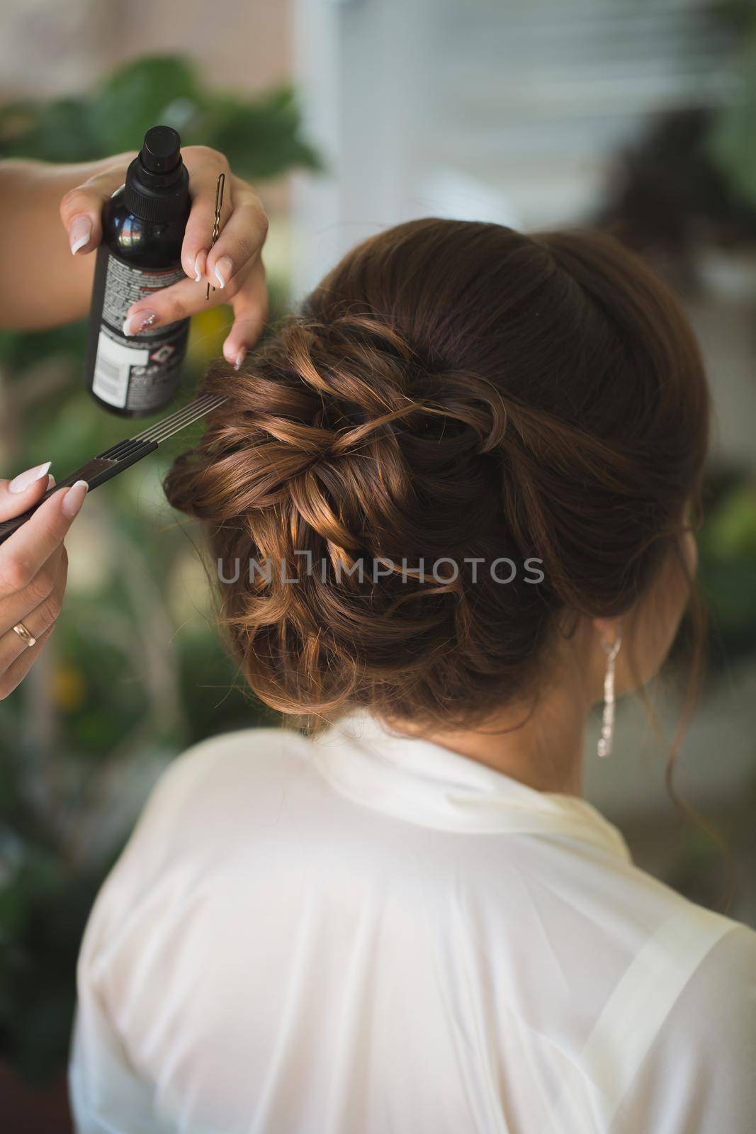 Master stylist makes the bride wedding hairstyle using spray lacquer fixing. by StudioPeace