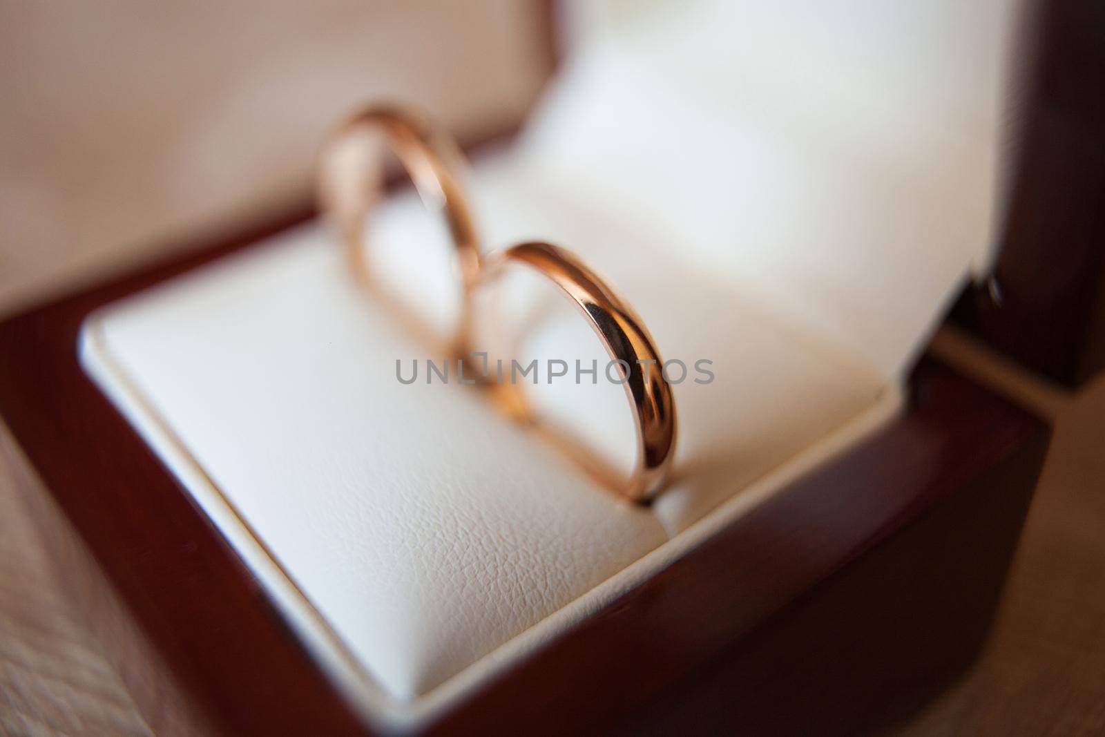 Elegant gold wedding rings in a wooden box by StudioPeace