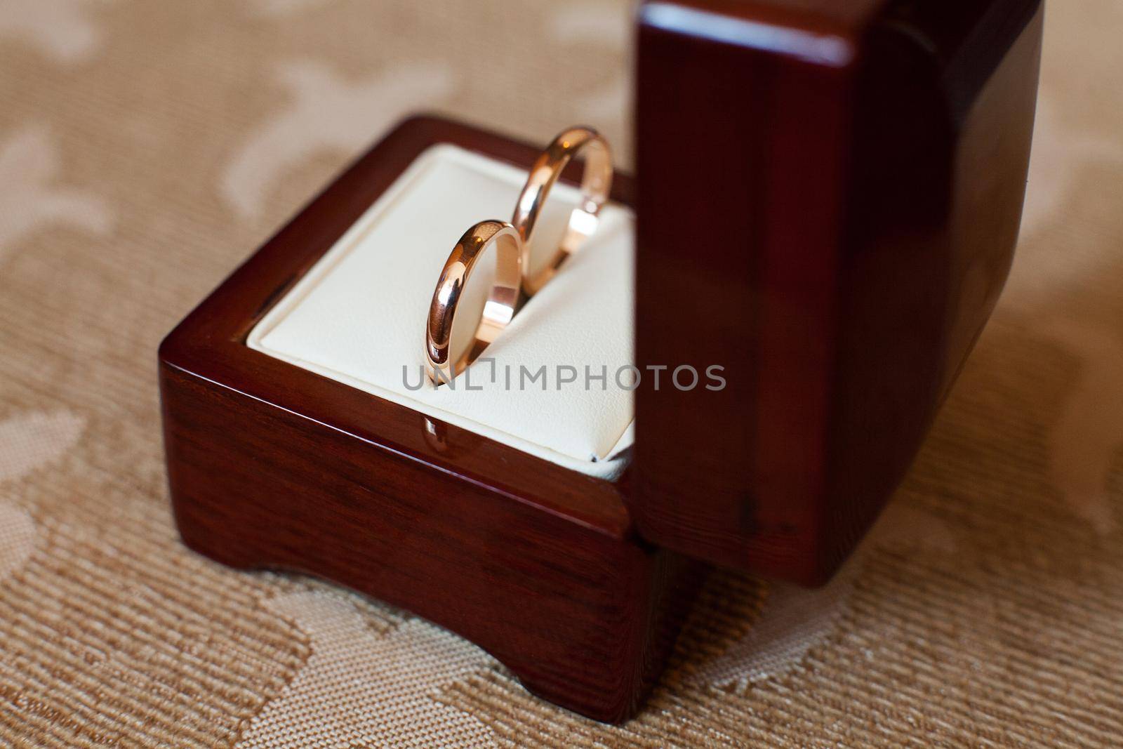 Elegant gold wedding rings in a wooden box.
