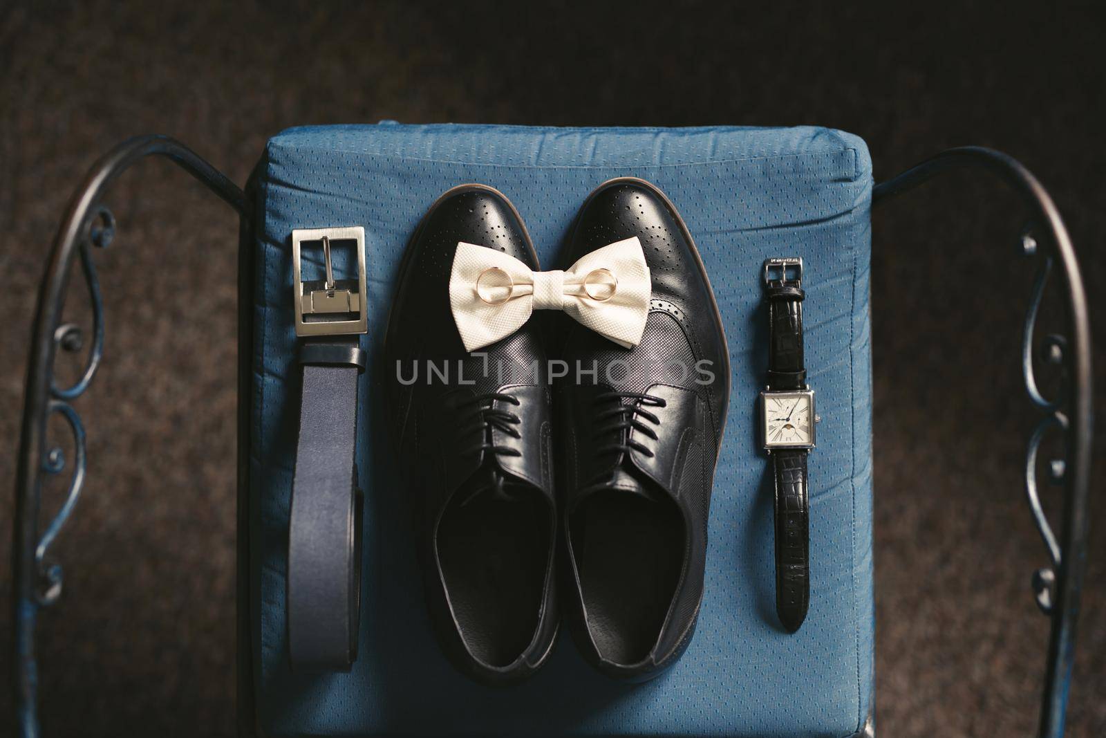 Men's shoes , watch, belt, tie and rings on a chair. The view from the top