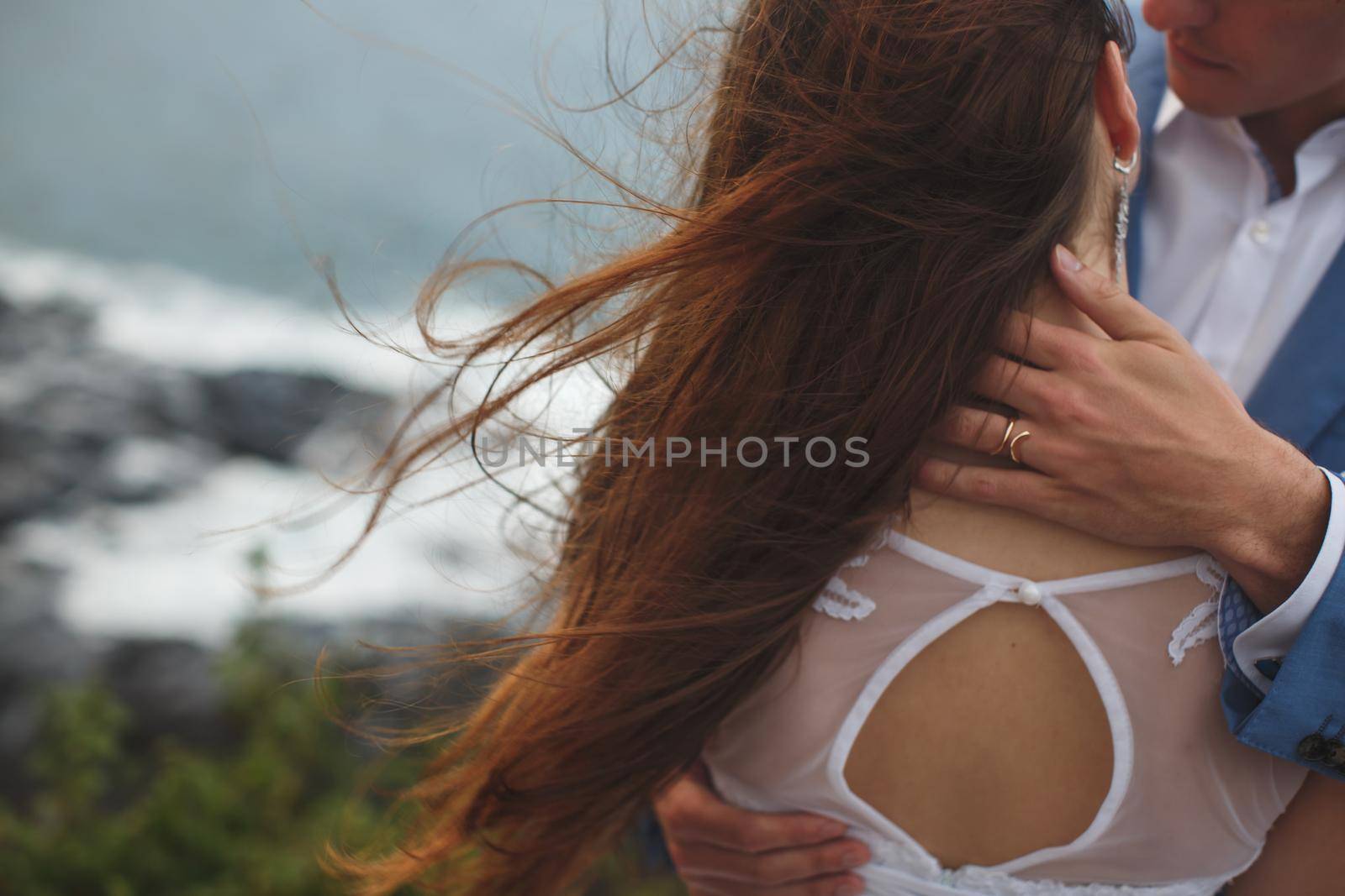 Close-up portrait of a bride and groom. Ocean. Sea. Hair. Wind by StudioPeace