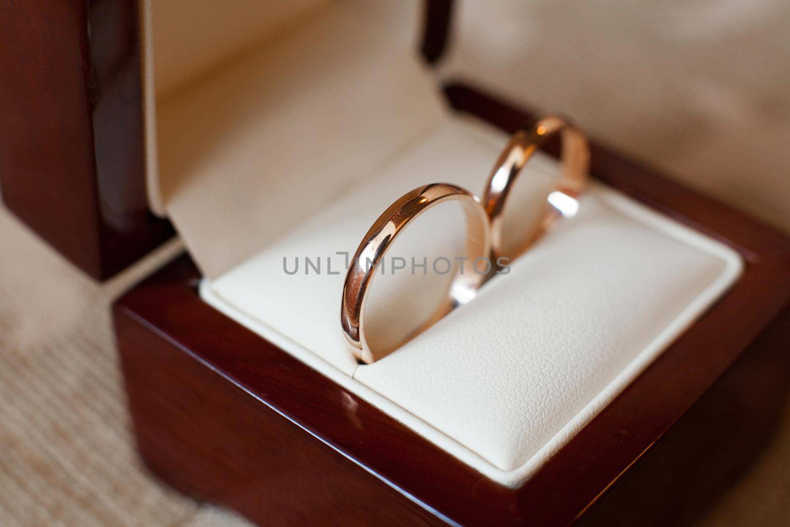 Elegant gold wedding rings in a wooden box by StudioPeace