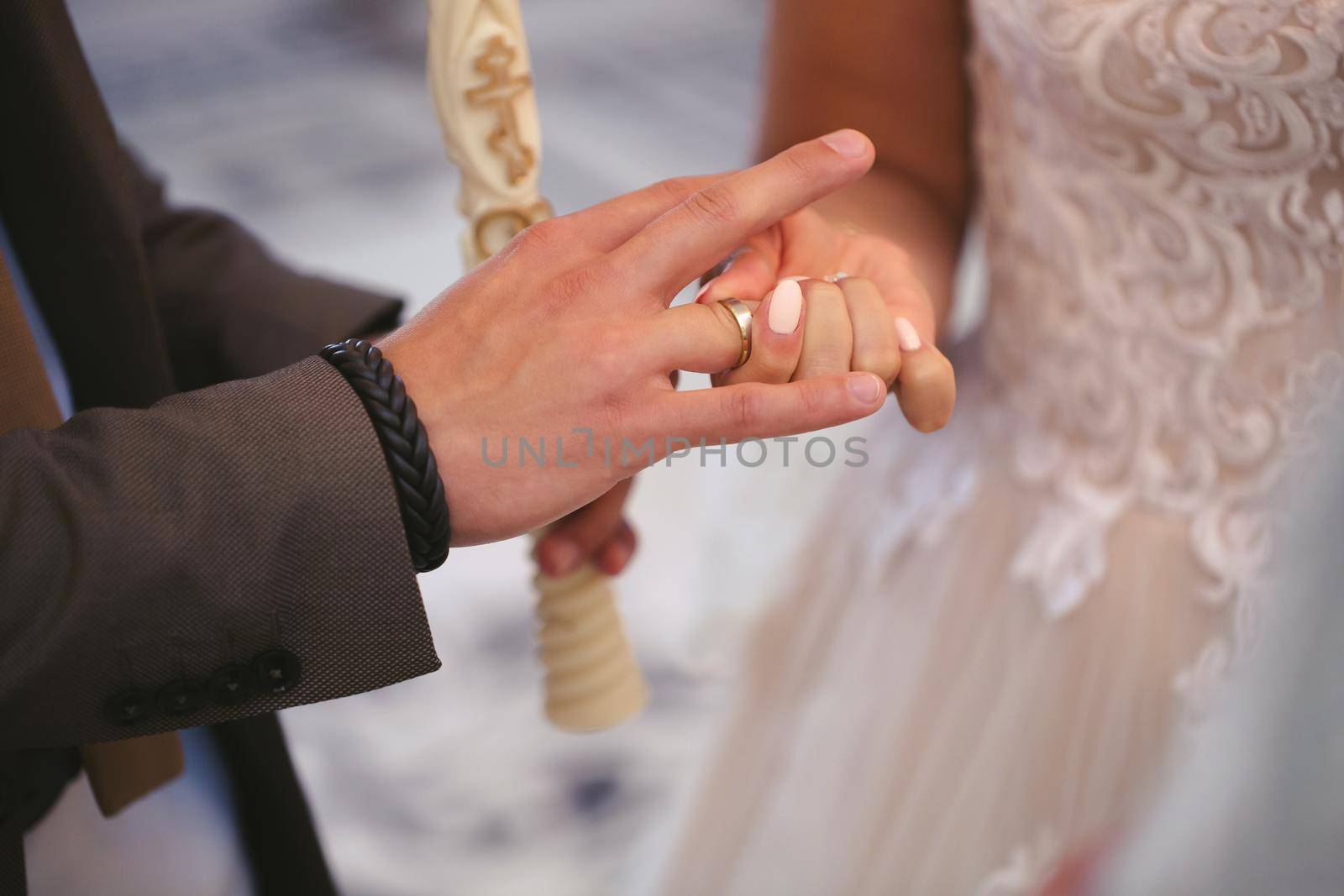 The groom puts the ring on the bride's finger in close-up