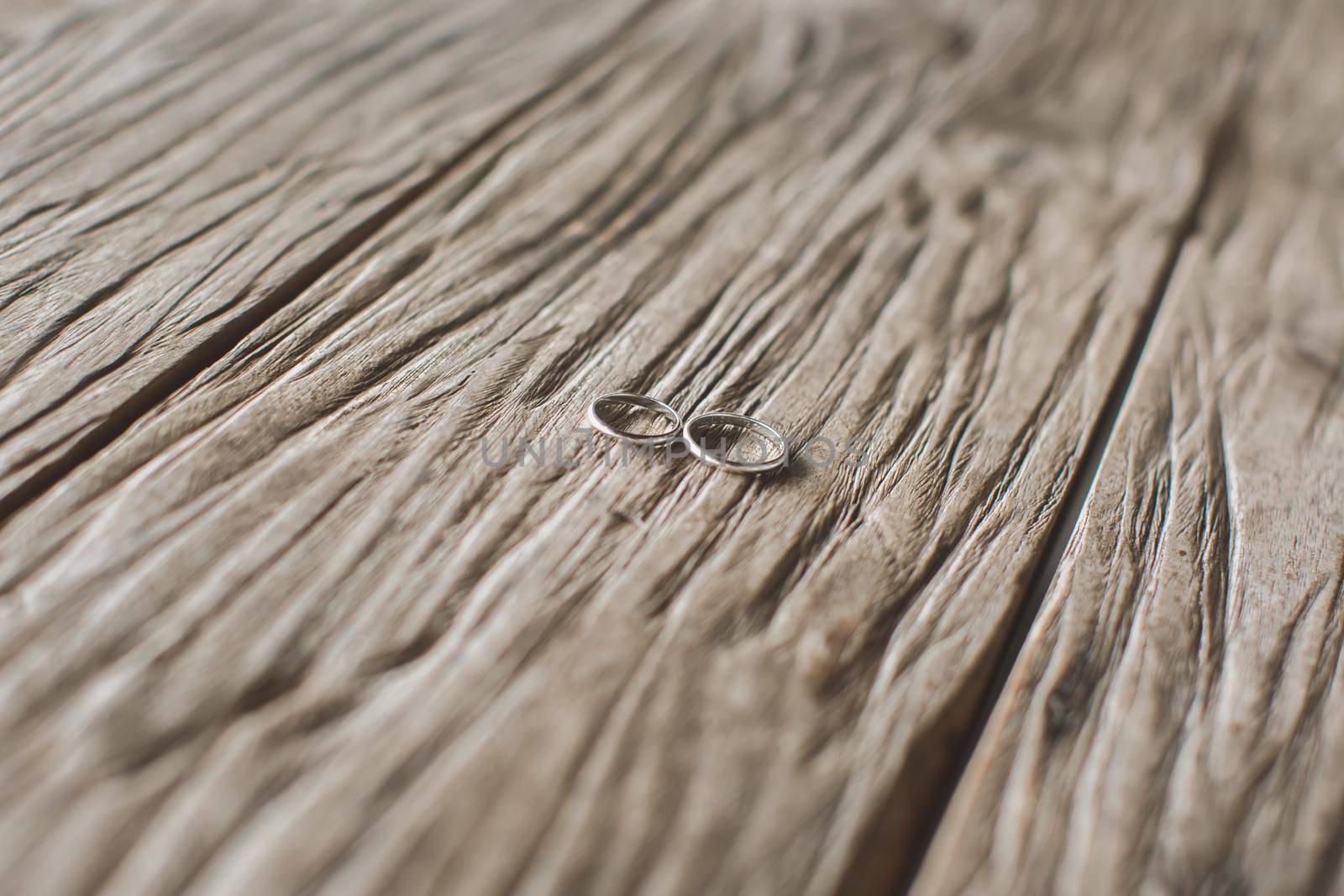 Macro shooting of gold wedding rings on the texture of wood by StudioPeace