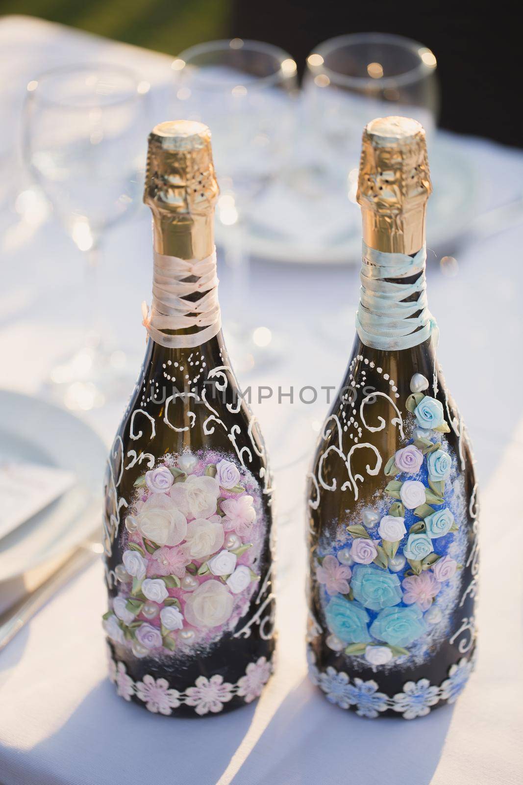 Decoration of a bottle of champagne and sparkling wine on table. Wedding decor by StudioPeace