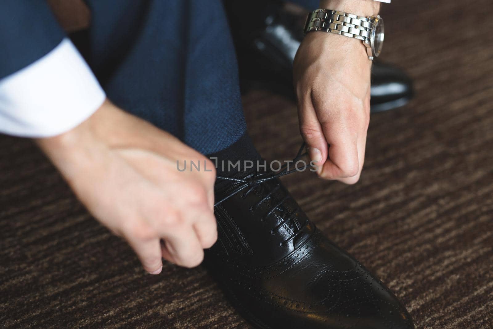 Man tying shoes laces on the wooden floor