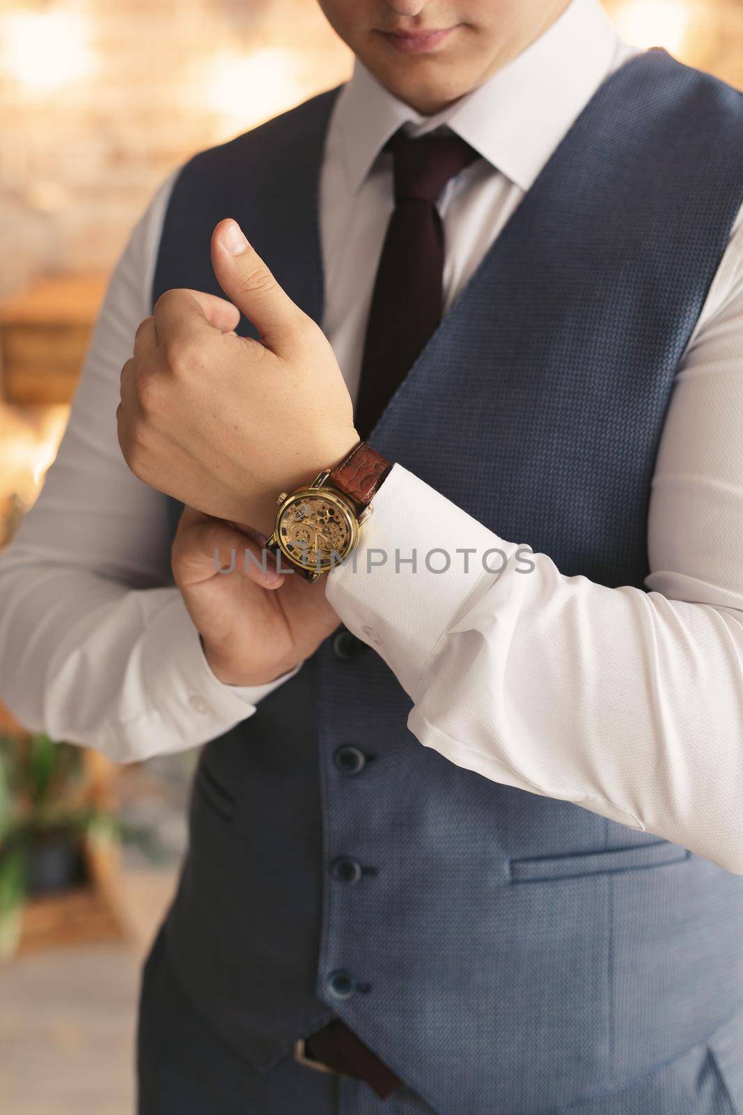 Close-up hands of the groom with a clock. by StudioPeace