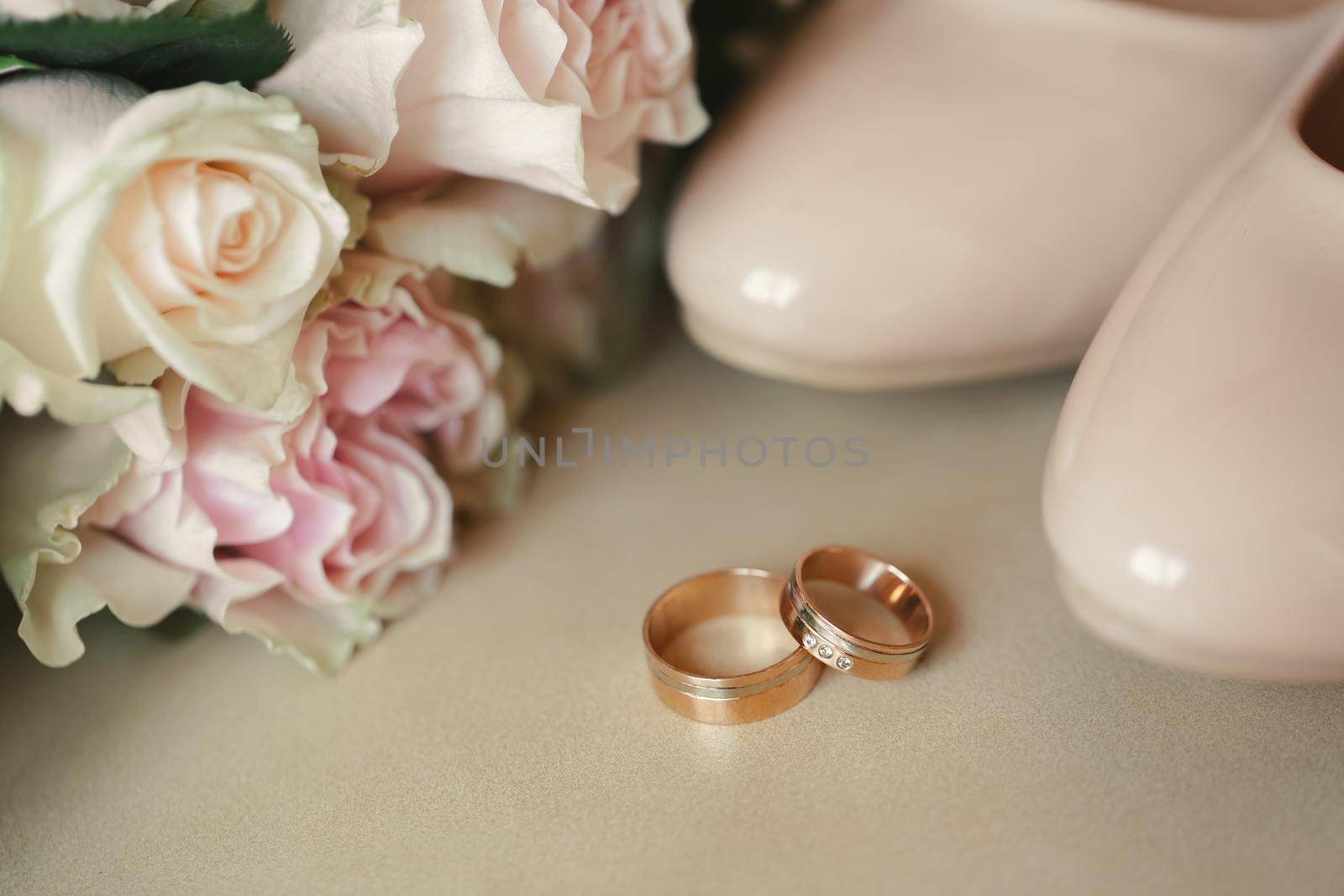 Shoes of the bride with rings and a bouquet