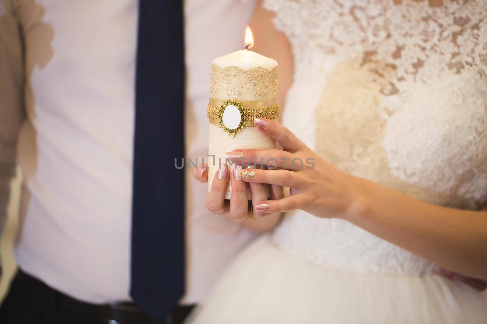 Wedding ceremony, paraphernalia, the bride and groom hold a large candle in their hand