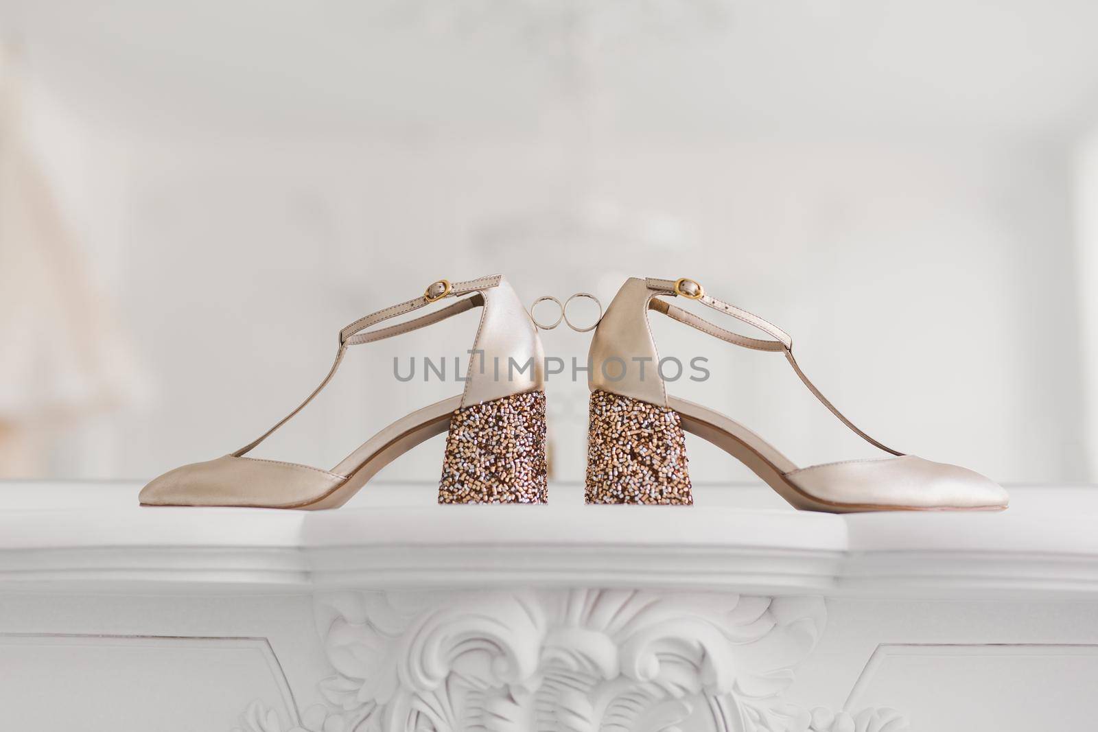 Gold wedding rings between the bride 's wedding shoes