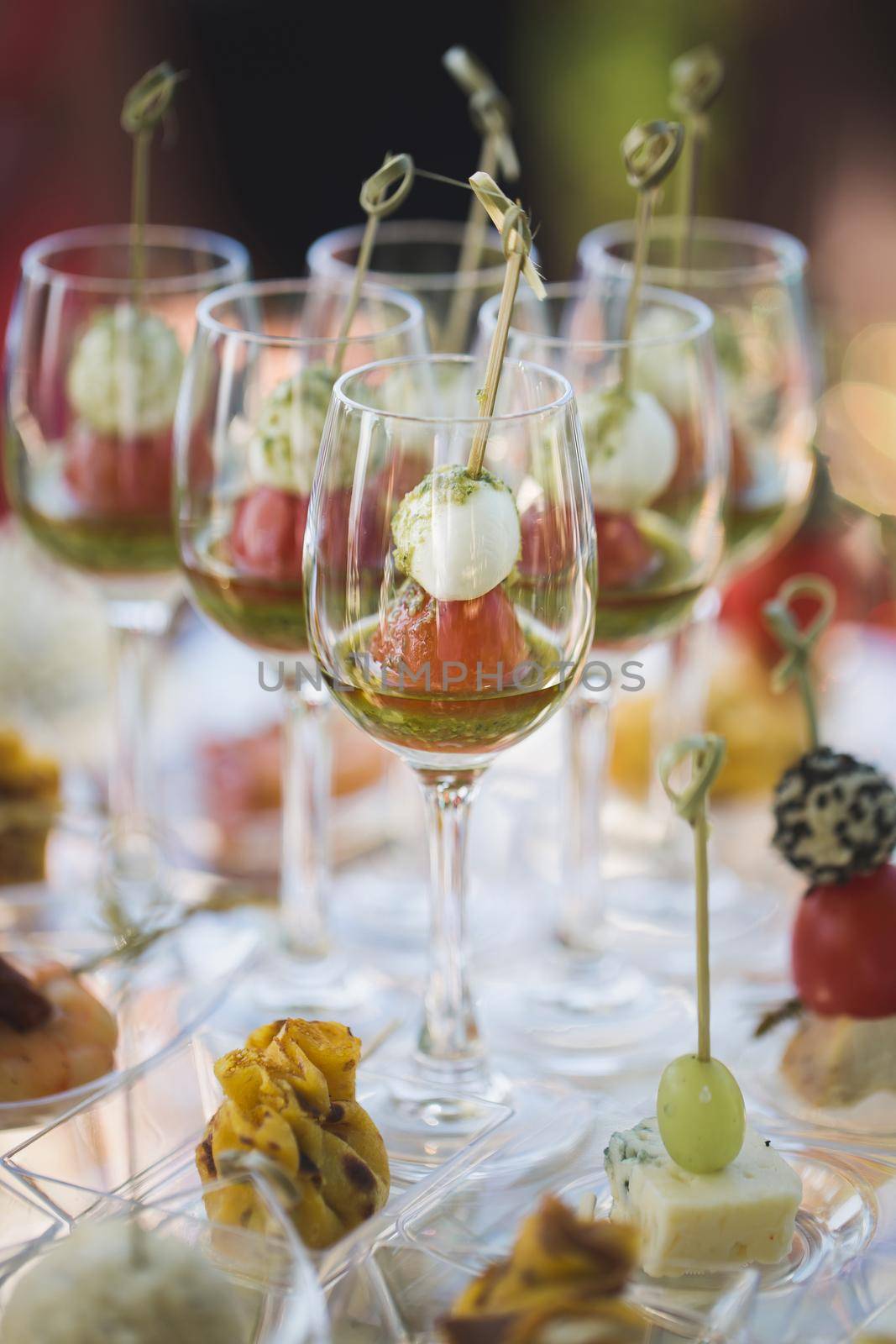 Reception at the wedding. Snacks and wine glasses on a glass table by StudioPeace