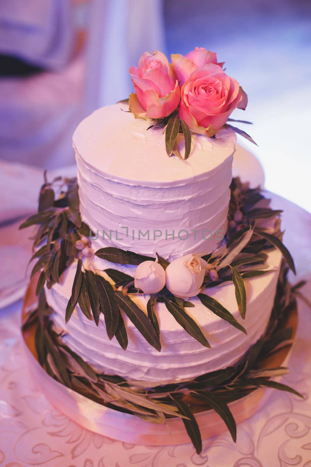 White delicate wedding cake with fresh flowers.