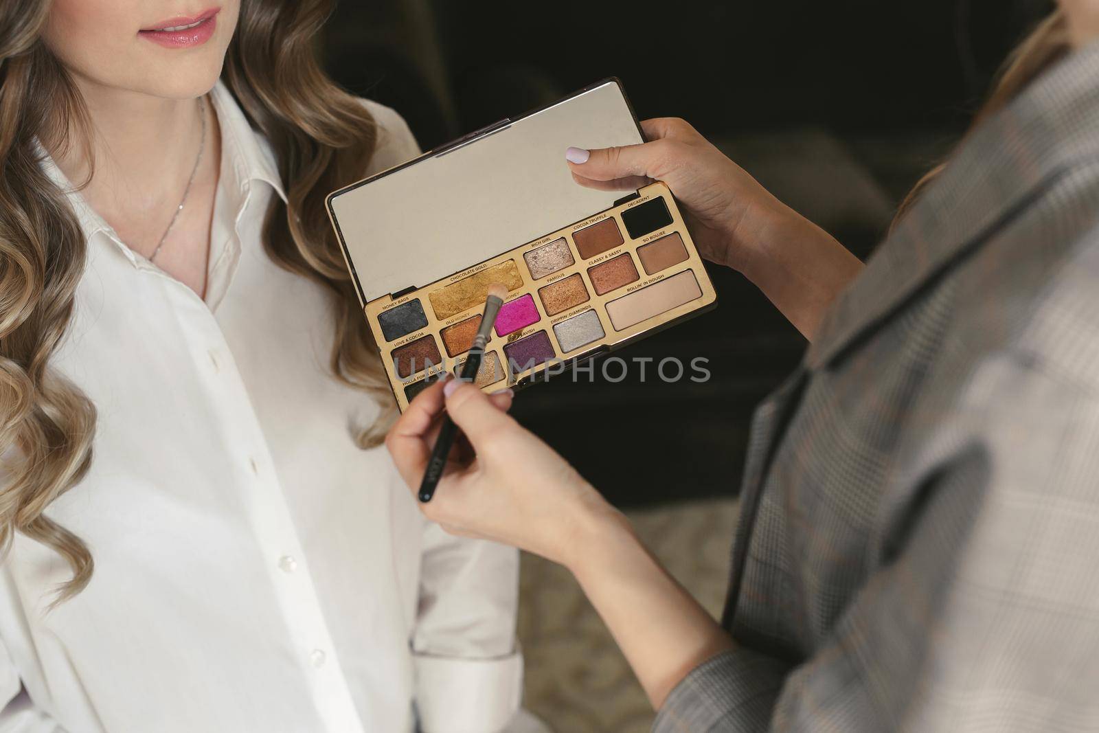 Young beautiful bride applying wedding makeup from a makeup artist. The morning training by StudioPeace