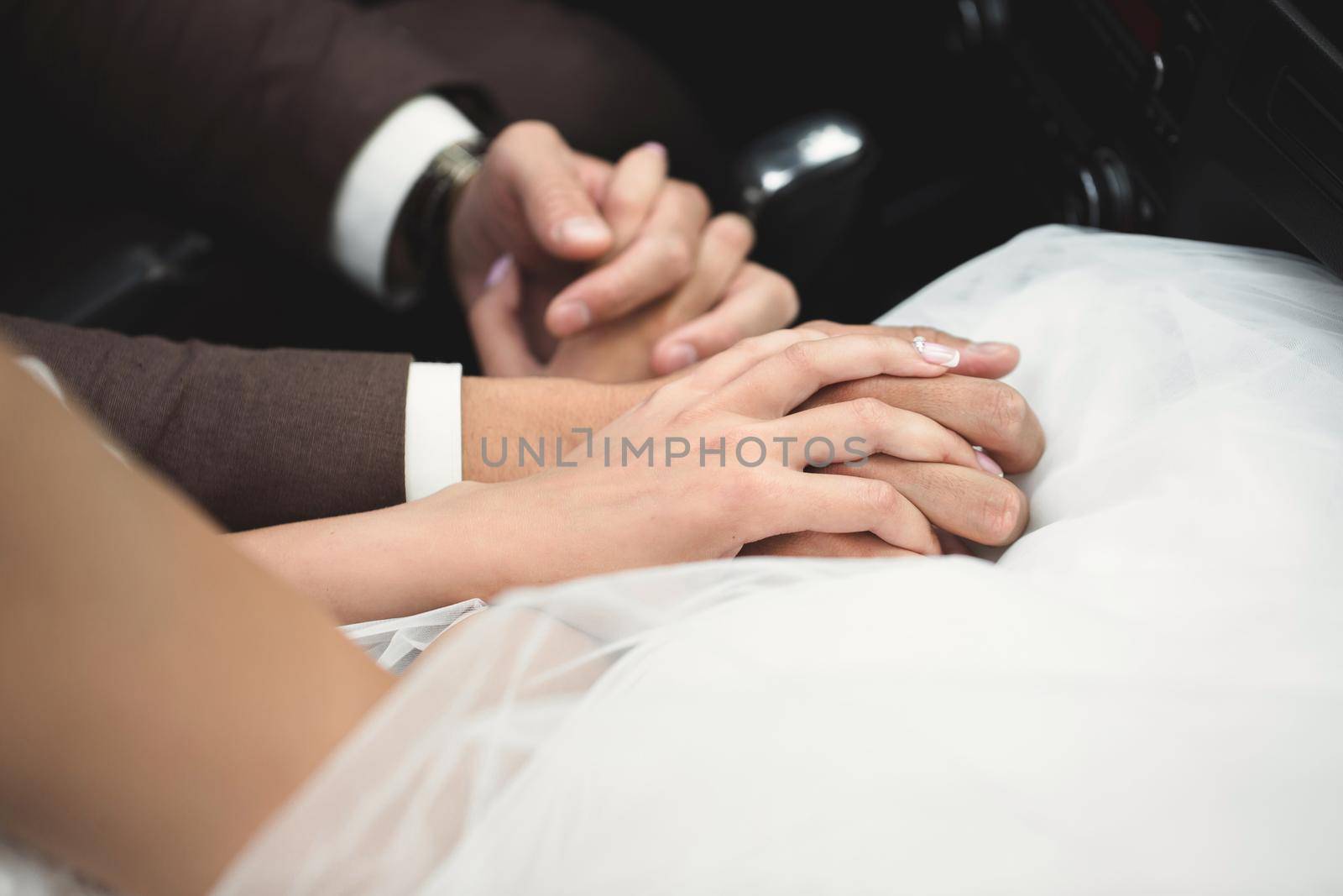 The bride and groom hold hands on the wedding day by StudioPeace
