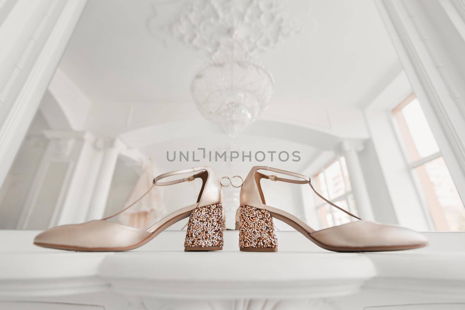 Gold wedding rings between the bride 's wedding shoes