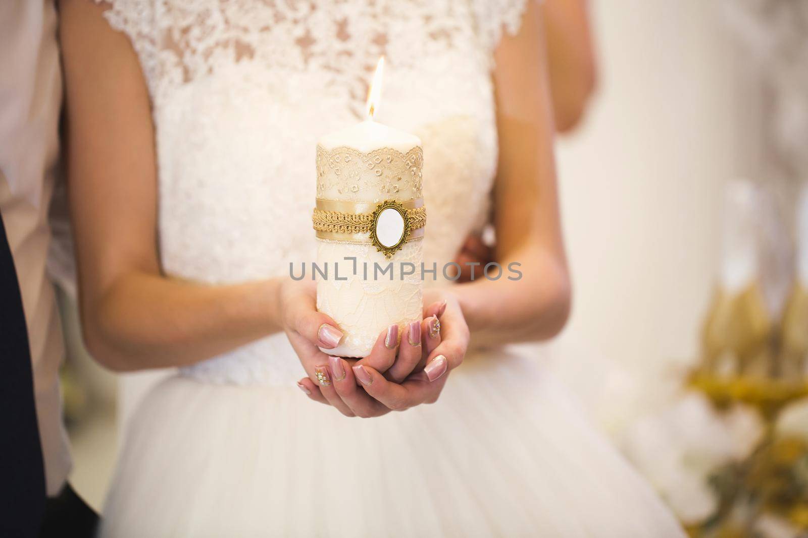 Wedding ceremony, paraphernalia, the bride and groom hold a large candle in their hand