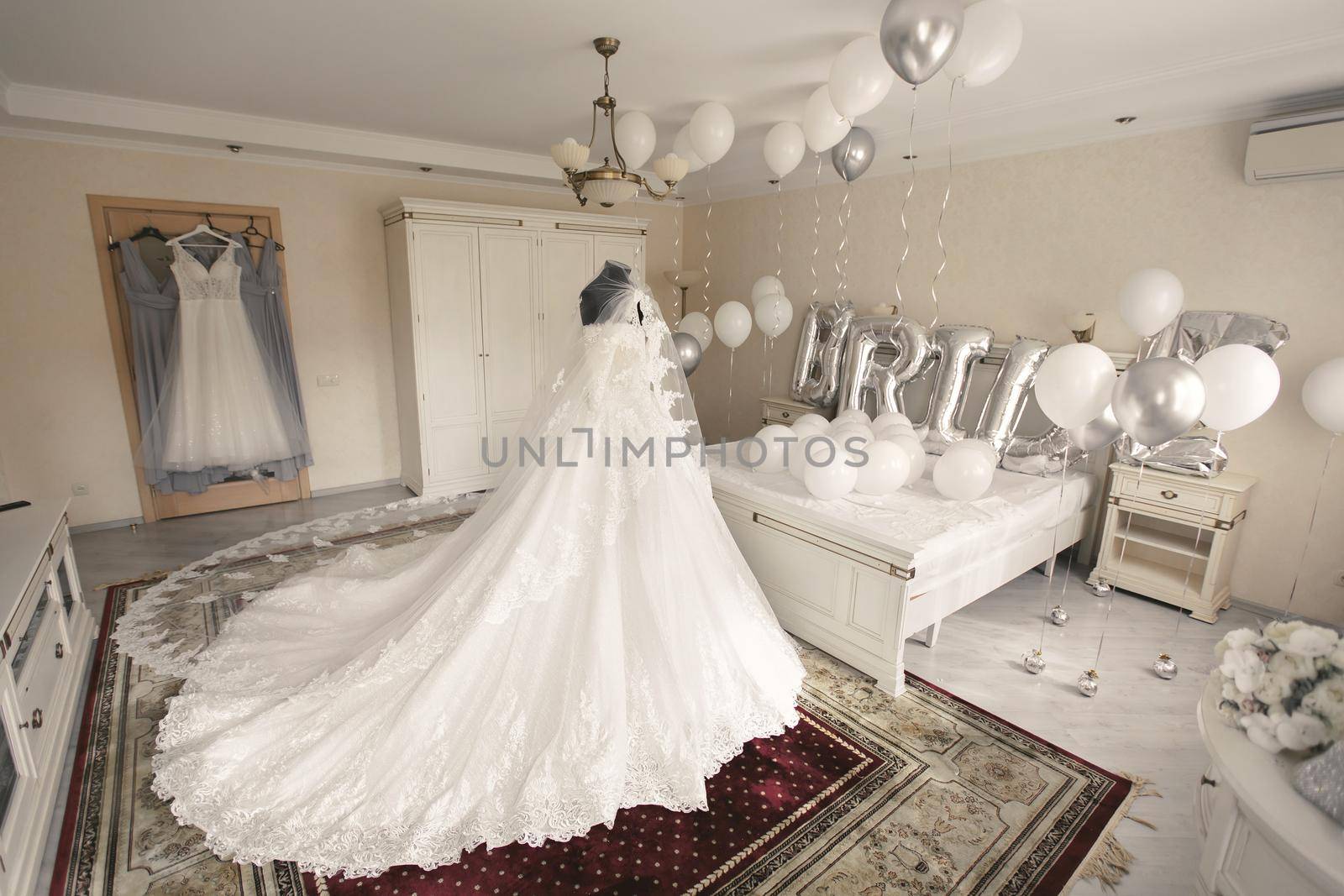 Chic wedding dress and veil on a mannequin in the bride 's gathering room