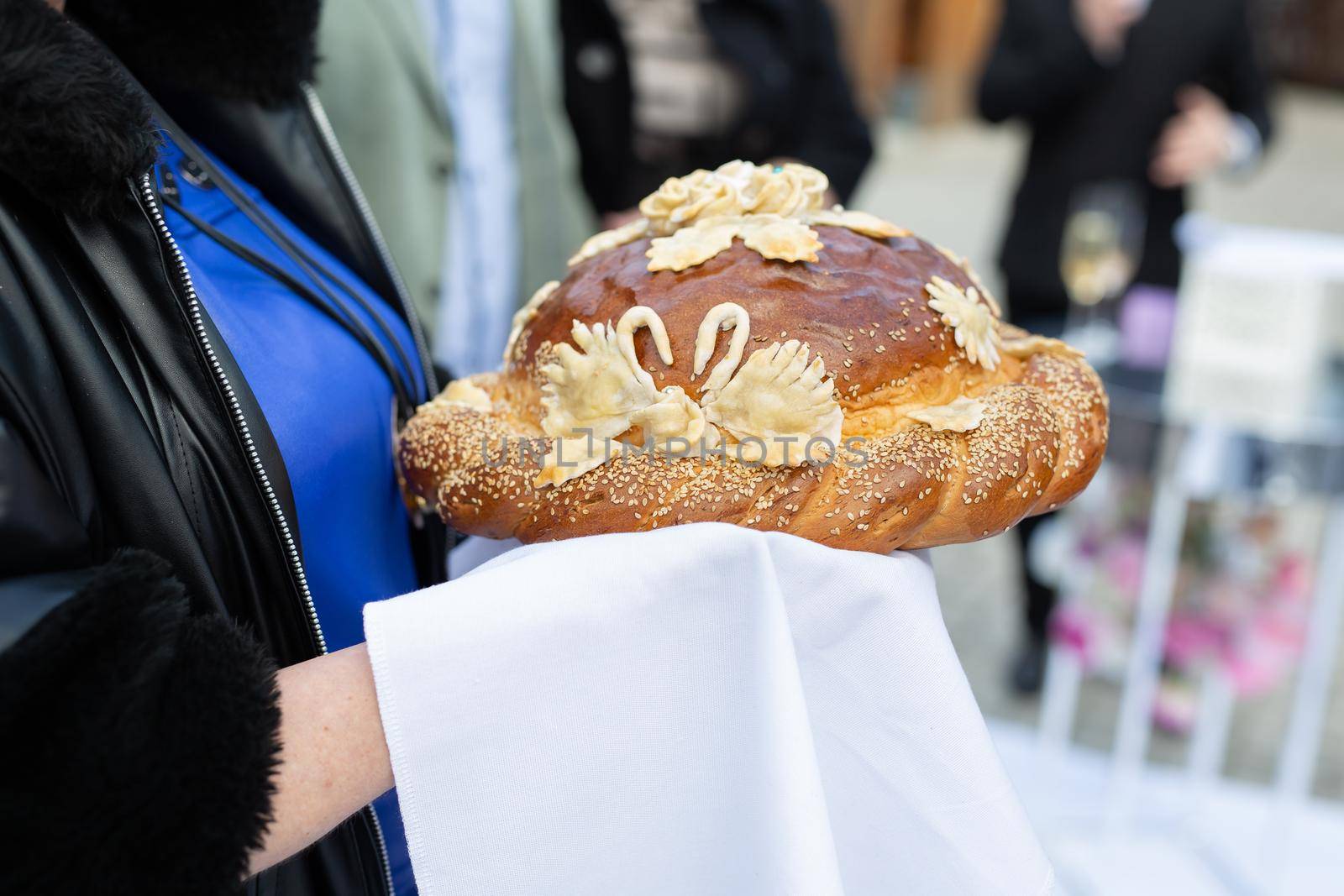 Wedding round loaf at the wedding in the hands of parents.